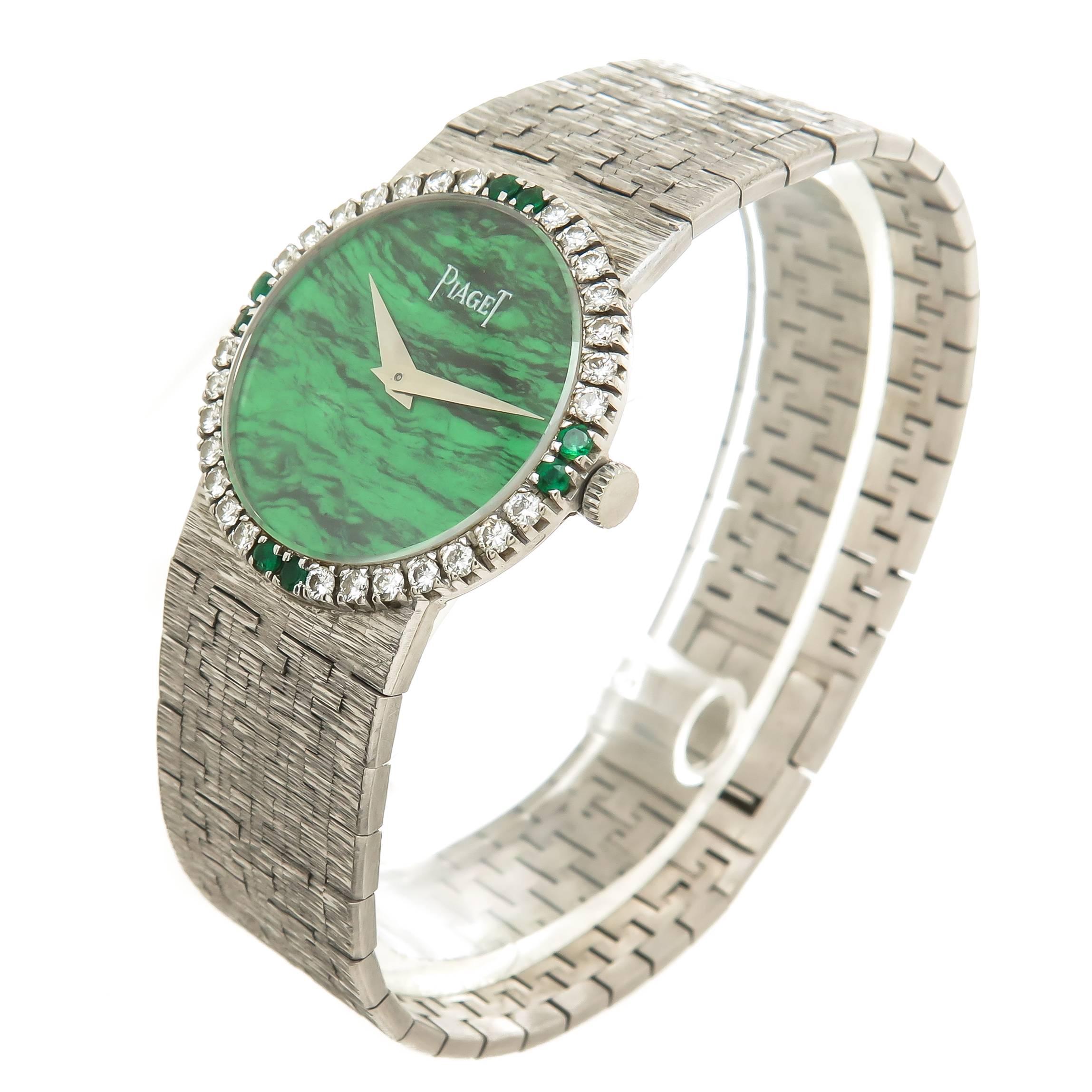 Circa 1970 Piaget Ladies Wrist Watch 18K White Gold water resistant case measuring 24 MM with Round Brilliant Cut Diamond and Emerald Bezel. 17 Jewel mechanical, manual wind Movement, Malachite Dial and White Gold Hands. 18K White Gold Piaget signed