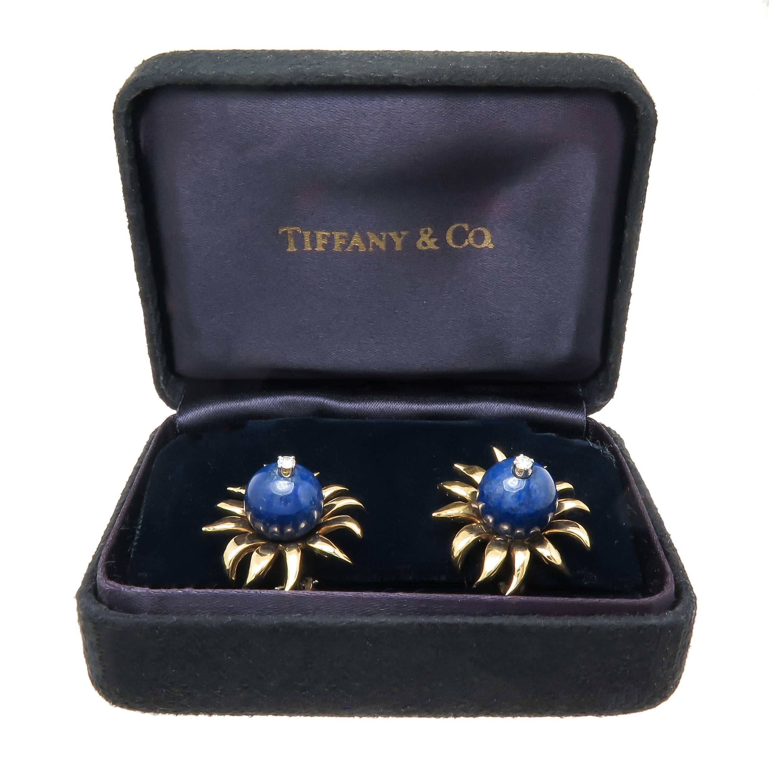Circa 1980s jean Schlumberger for Tiffany & Company 18k yellow Gold Earrings measuring 7/8 inch in diameter and centrally set with a Lapis lazuli measuring 11 MM and further set with a .05 Carat Diamond. having Omega Clip backs to which a Post