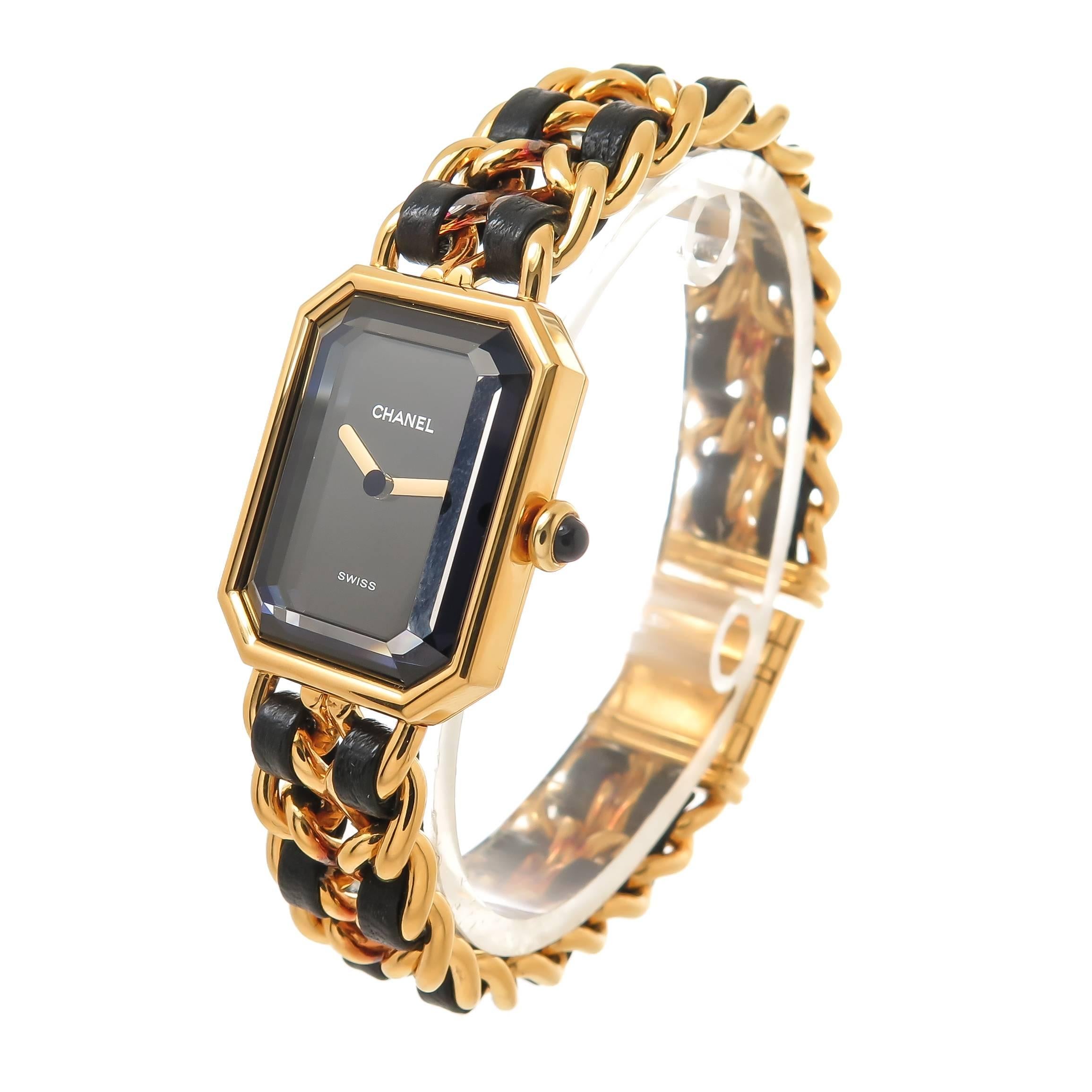 Circa 2010 Chanel Premiere collection Ladies Wrist Watch, 26 X 20 MM Water Resistant Gold Tone Case, Quartz Movement, Black Dial and a Faceted synthetic Sapphire Glass Crystal. 1/2 inch wide Gold tone and woven Black Leather bracelet. Total Watch
