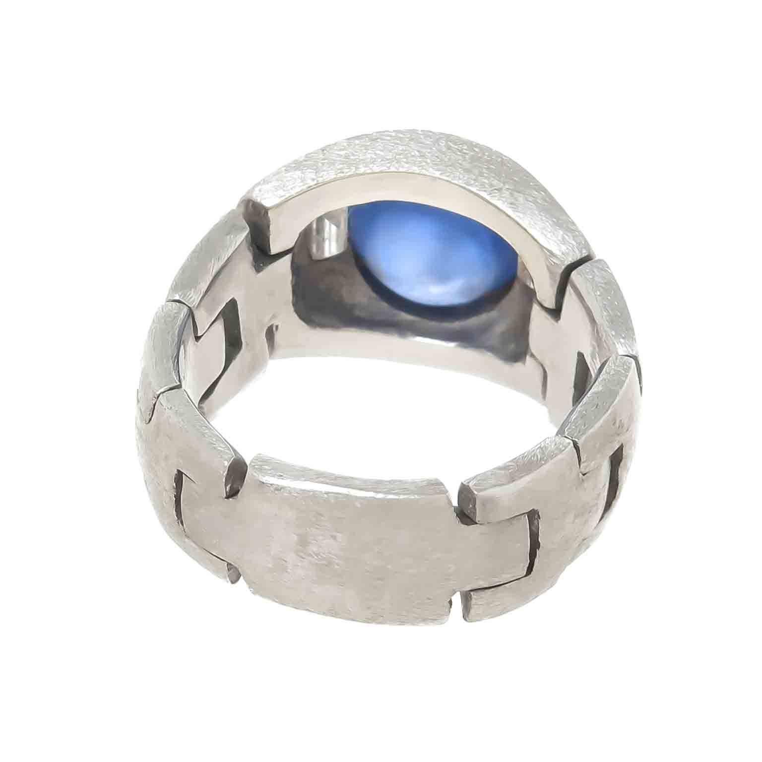 Circa 1930s unique Platinum linked Ring measuring 1/2 X 5/8 inch across the top and having tapering links from 3/8 to 1/4 inch wide. Cenrally set with a fine color Cabochon Sapphire measuring 9 X 6 MM and being approximately 4 + Carats. Further set