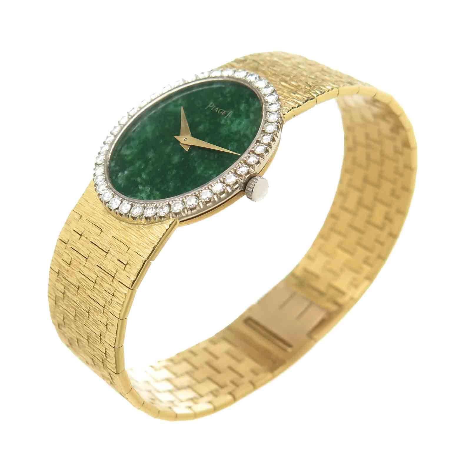 Circa 1980 Piaget 18K yellow Gold Ladies Wrist Watch. The oval case measures 27 X 24 MM and is 5 MM thick. Factory White gold Bezel set with fine White Round Brilliant cut Diamonds totaling 1 Carat. Mechanical, manual wind 17 Jewel Movement. Green