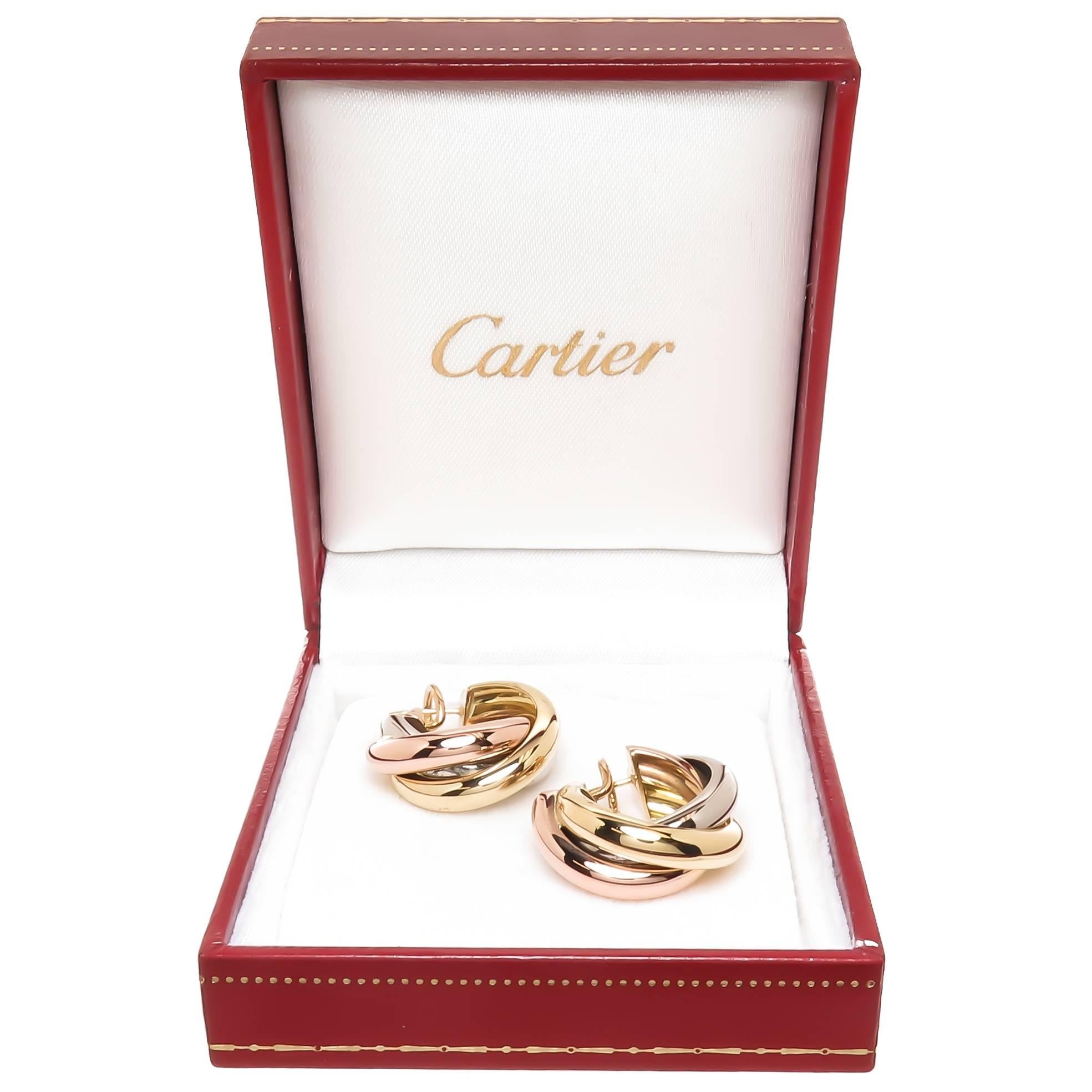 Circa 2005 Cartier Trinity 18K yellow, Pink and White Gold Tri color Earrings, measuring 1 inch in diameter and 3/8 inch wide. Having Omega Clip backs with a post. Come in a Cartier Gift Box. 