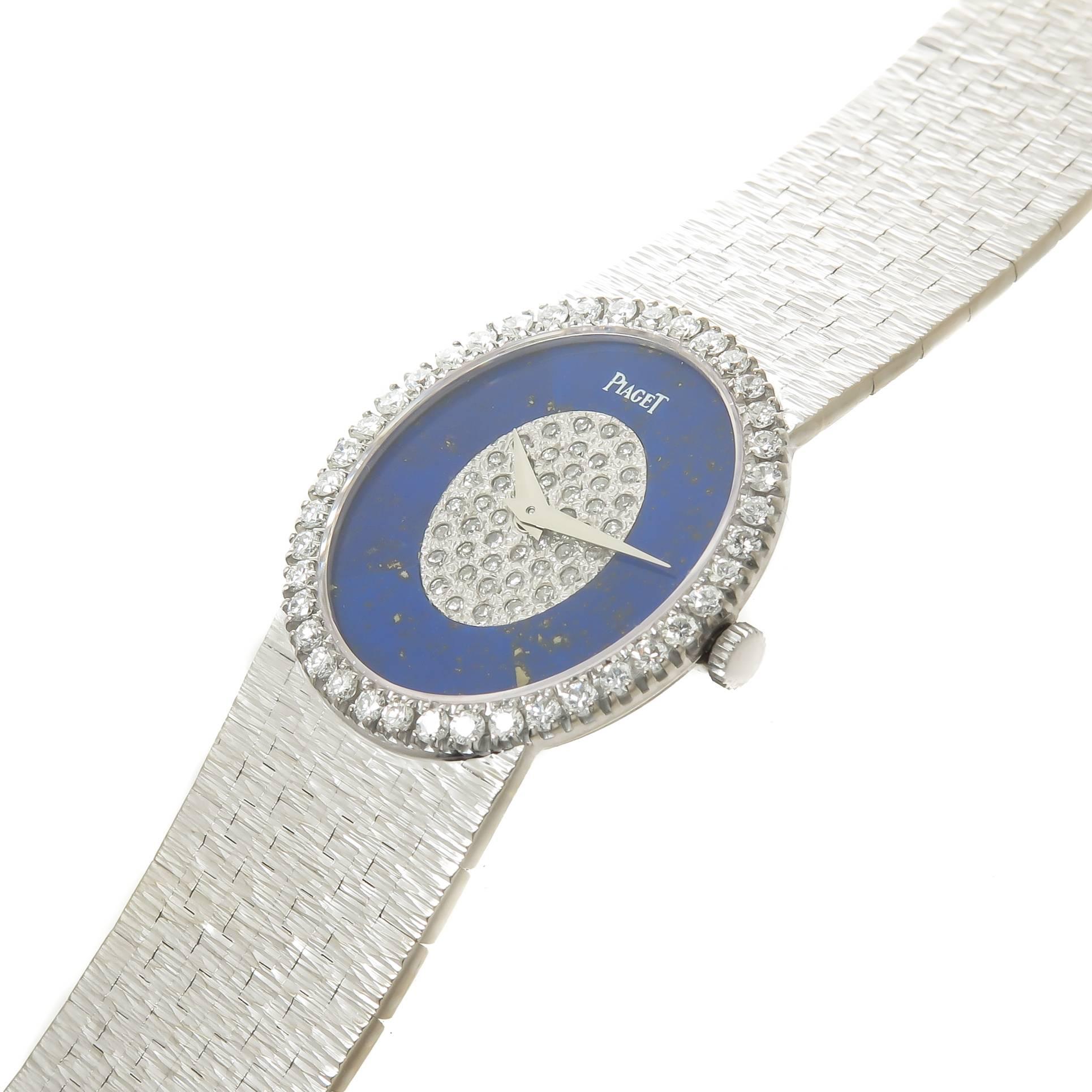 Circa 1970 Piaget Ladies wrist watch, 27 X 24 MM 18K White Gold Oval case with a Factory original Diamond set bezel of Fine White Round Brilliant cuts totaling 1 Carat. 17 Jewel mechanical, manual wind Movement, Lapis Lazuli Dial with a Center of