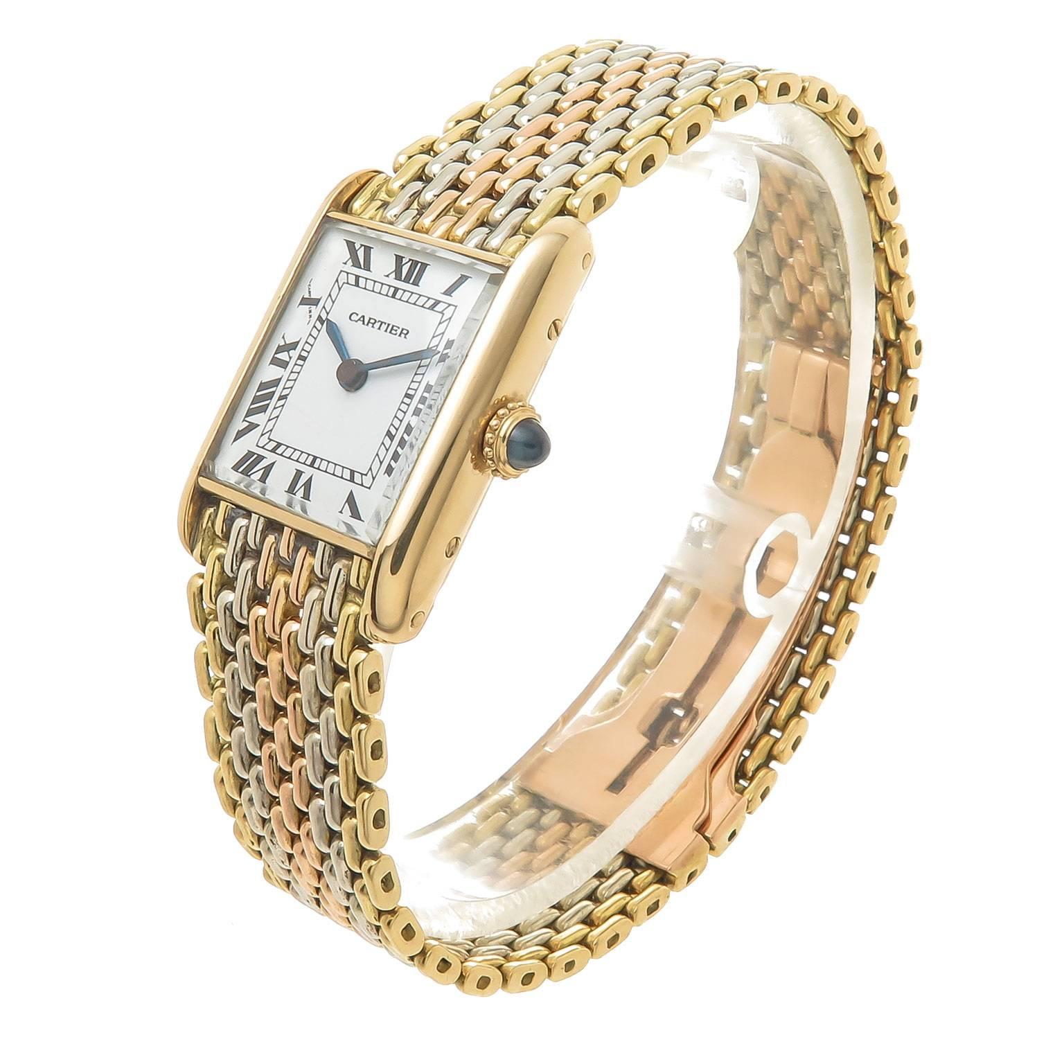 Circa 1980 Cartier Ladies Tank Watch on a Tri Color Gold Cartier bracelet. 25 X 23 MM 18K Yellow Gold Case, Mechanical, manual wind movement, White Enamel Dial with Black Roman Numerals, Sapphire Crown. 5/8 inch wide White, Yellow and Rose Gold Link