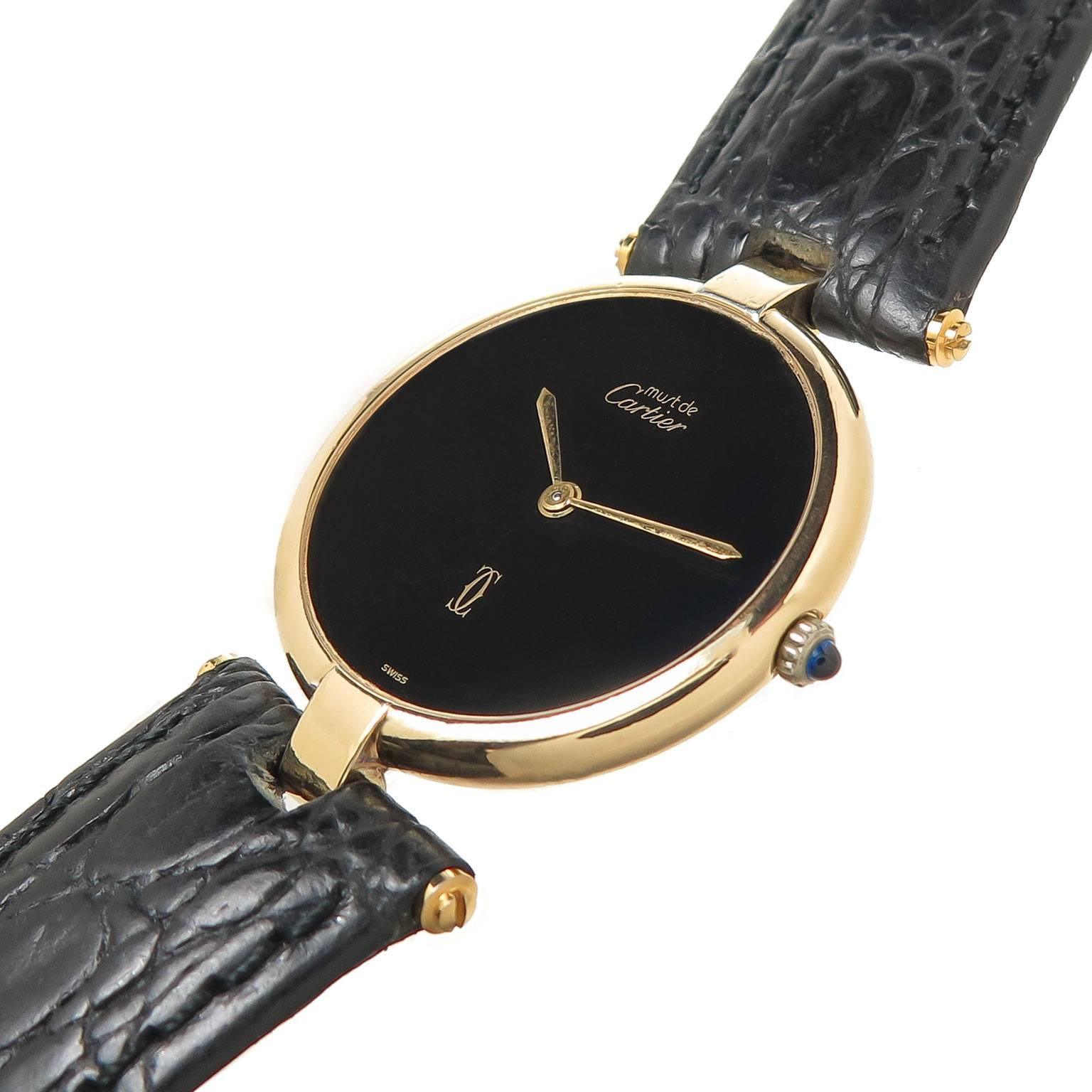 Circa 2000 Cartier Vendome, Must de Cartier  Wrist Watch, 30 MM Gold Plate, Sterling Silver ( Vermeil ) Case. Quartz Movement, Black Dial and a Sapphire Crown. Hadley Roma, Black leather strap with a Gold Plate Cartier Tang Buckle. Comes in a
