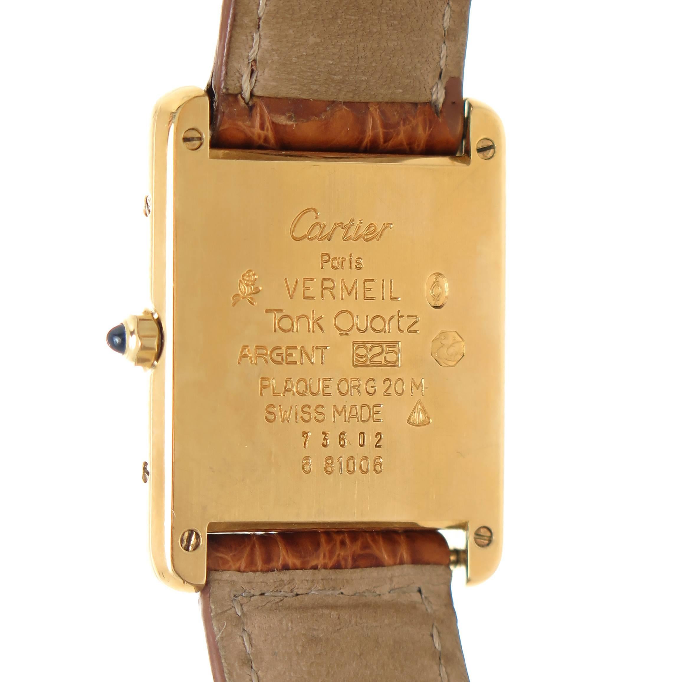 Circa 2010 Cartier Tank Vermeil Wrist Watch, 30 X 23 MM Gold Plate on sterling Case, Custom set Diamonds on each side of the case totaling 3/4 carat. Quartz Movement, Gold Dial with Black Roman Numerals. Light Brown Cartier Strap with Gold Plate