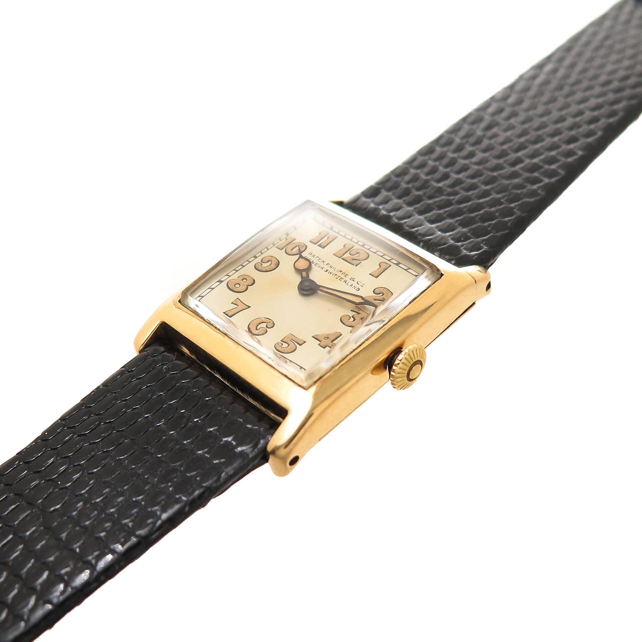 Circa 1920s Patek Philippe Wrist watch, 33 X 25 MM 18K yellow Gold Case, 5 MM in thickness. 18 Jewel Manual wind, mechanical movement.  Original silvered Dial with Luminous Markers. New Black Lizard Strap, total watch length 8 3/4 inch.
