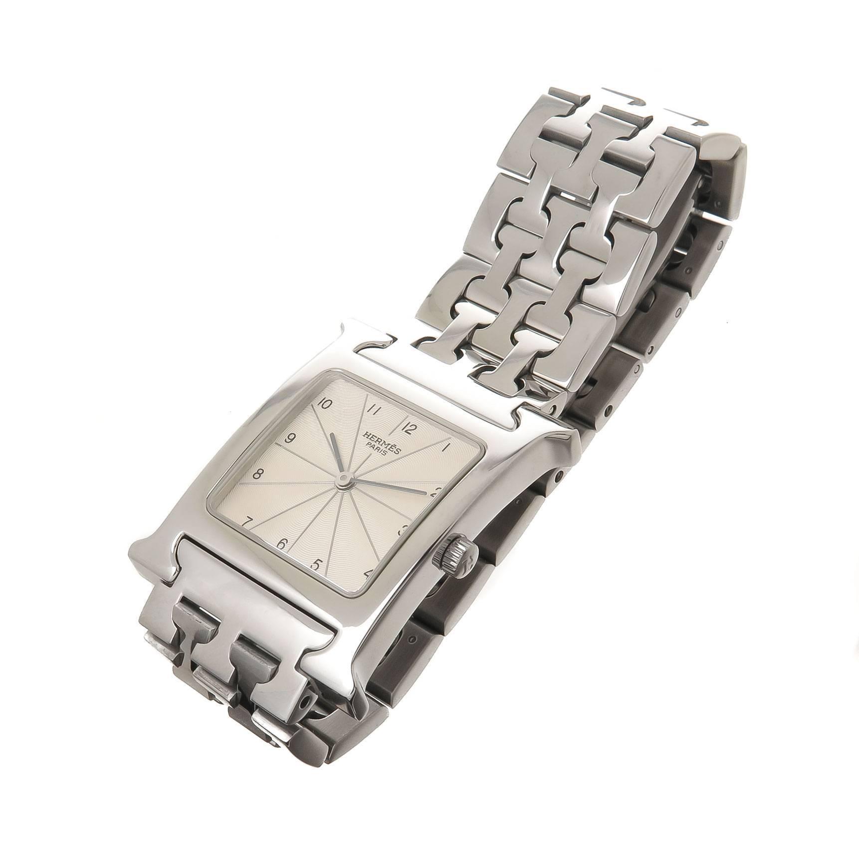 Circa 2012 Hermes H Collection Wrist Watch, 35 X 26 MM Stainless Steel case. Silver Engine Turned Dial with raised markers. Quartz Movement. 3/4 inch wise Steel H Bracelet with fold over Deployment clasp. Wrist size 6 Inches. Comes In original