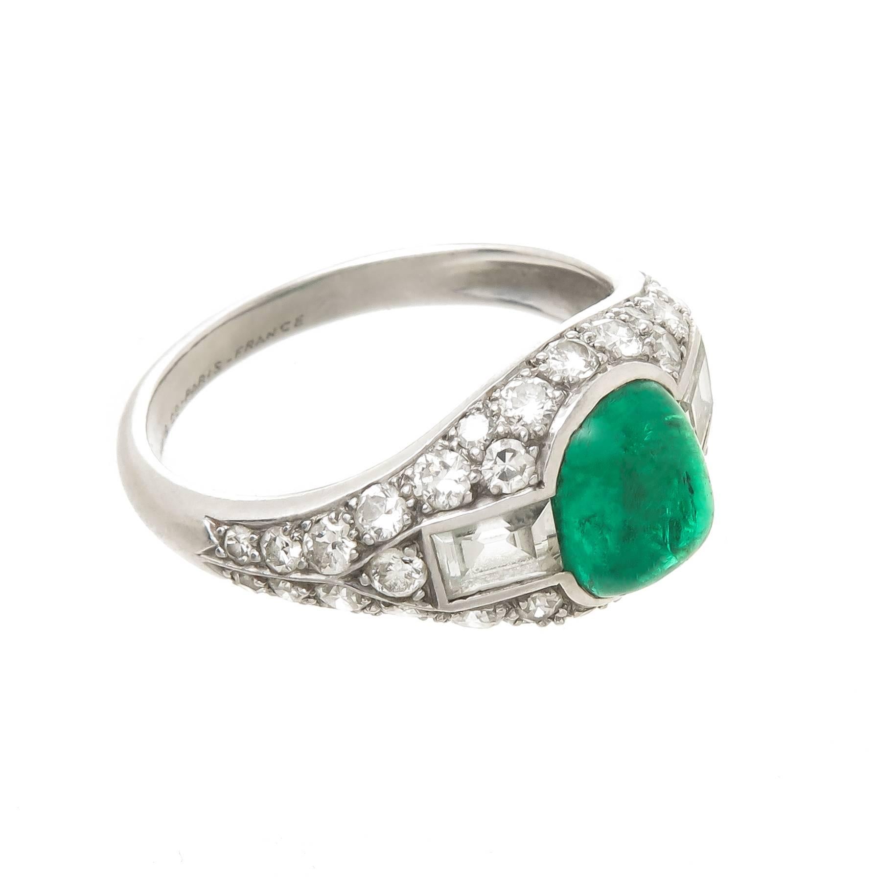 Circa 1925 Tiffany & Company Platinum Ring, retailed at the Tiffany & Company store in Paris. Centrally set with a Fine Color Sugar Loaf Cabochon Emerald measuring 7.6 x 6.5 x 5.10 approximately  2 carats. Further set with 2 stepped cut and numerous
