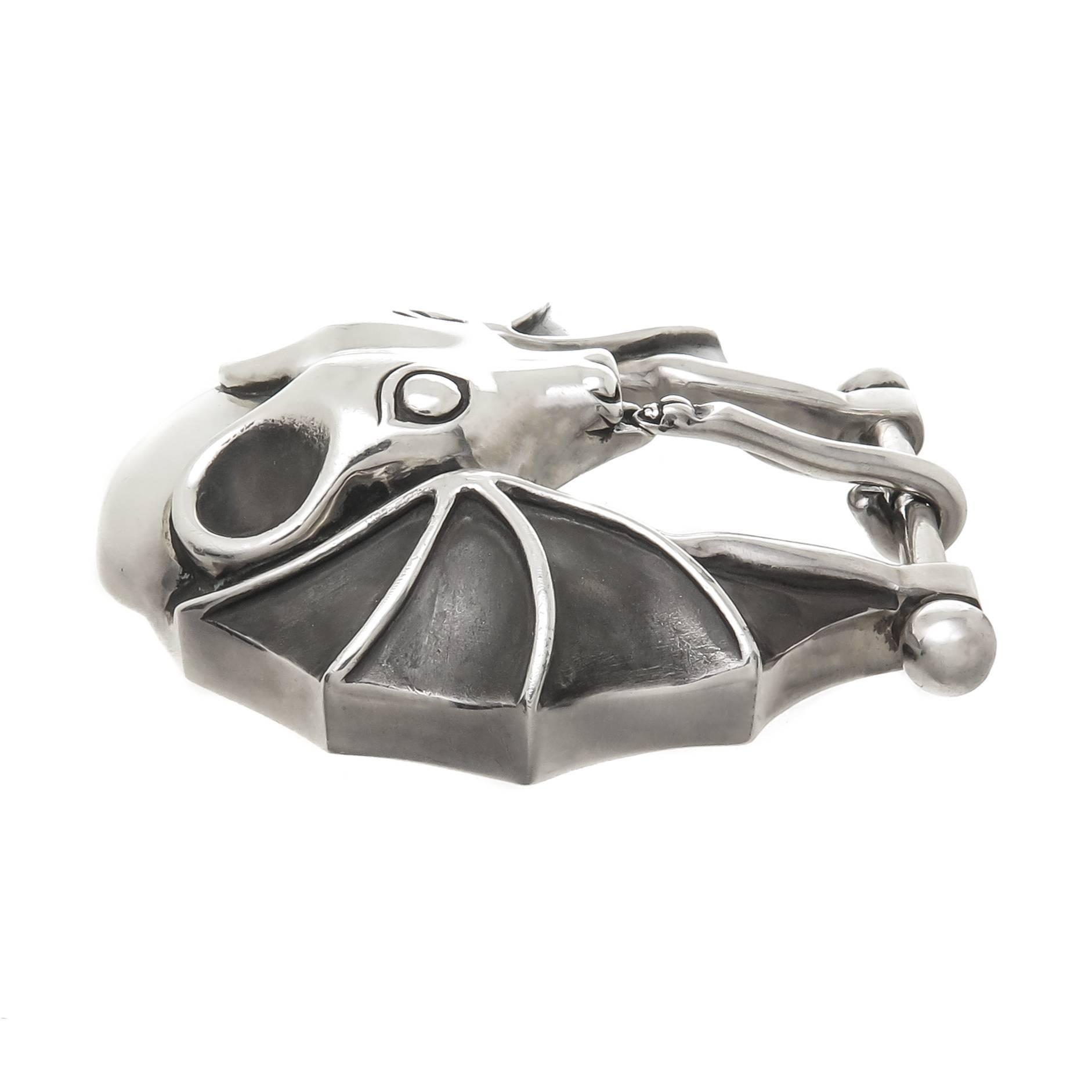 Circa 1990s Too Cool, Sterling Silver Bat Belt Buckle by Barry Kieselstein Cord, measuring 2 1/2 X  2 1/2 inch and weighing 3 ounces, having a bright polish finish with a dull gray finish in the Wings. Fits a 1 inch wide belt. 