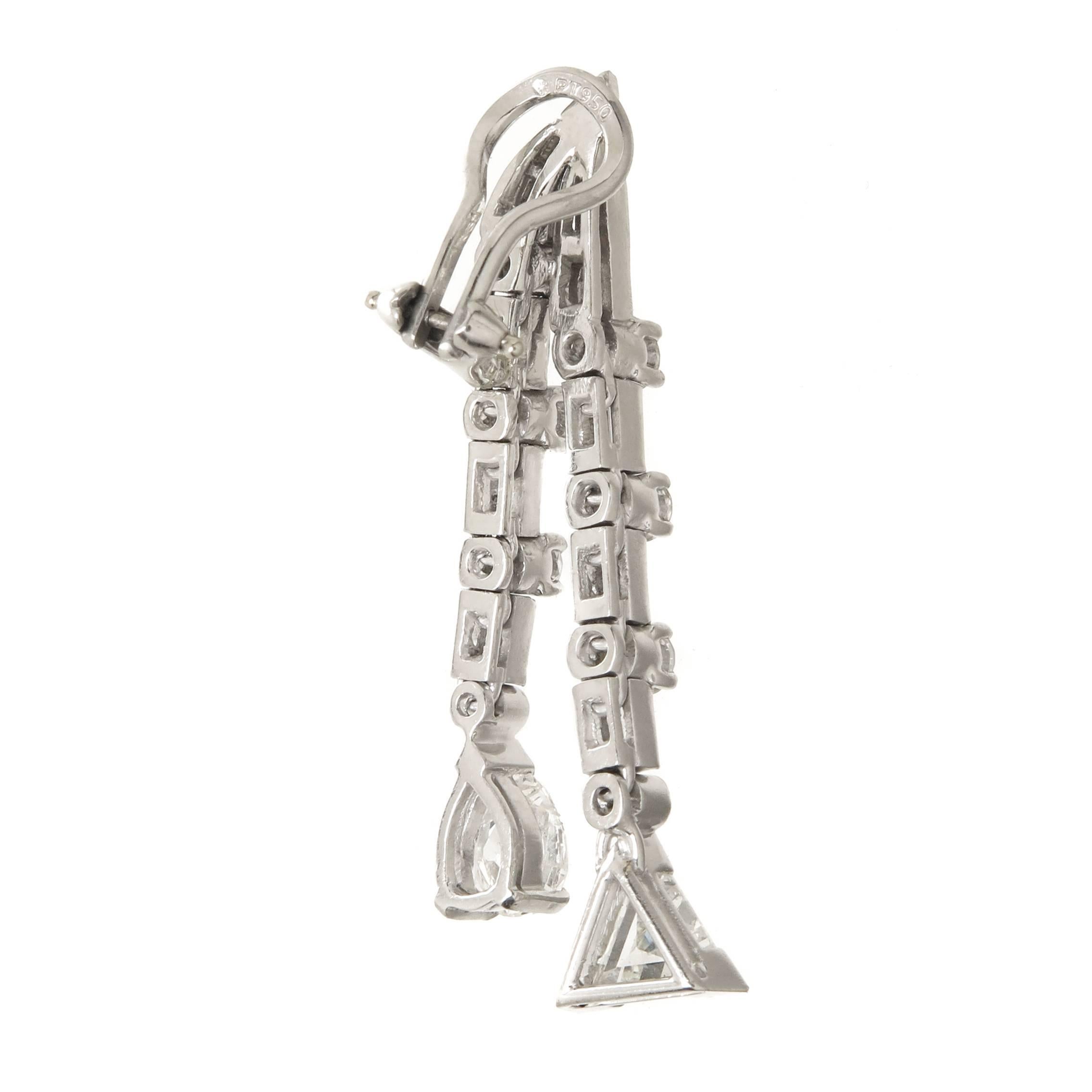 Circa 1940s Platinum Dangle Drop Earrings, measuring 1 1/2 inch in length and set with Pear, Trillion, Round and Baguette Diamonds totaling 4.50 carats and grading as G -H in Color and VS in Clarity.  Having Omega clip backs to which a post can be