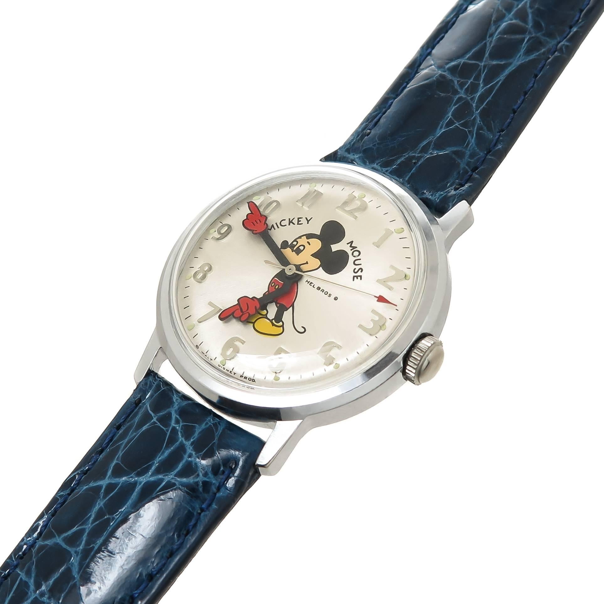 Circa 1970s Helbros Mickey Mouse Wrist Watch, 34 MM Diameter Stainless Steel Water Resistant case also measuring 6 MM thick. 17 Jewel Mechanical, Manual wind Movement. Silvered Dial with Raised markers, sweep seconds hand and a colorful Mickey Mouse