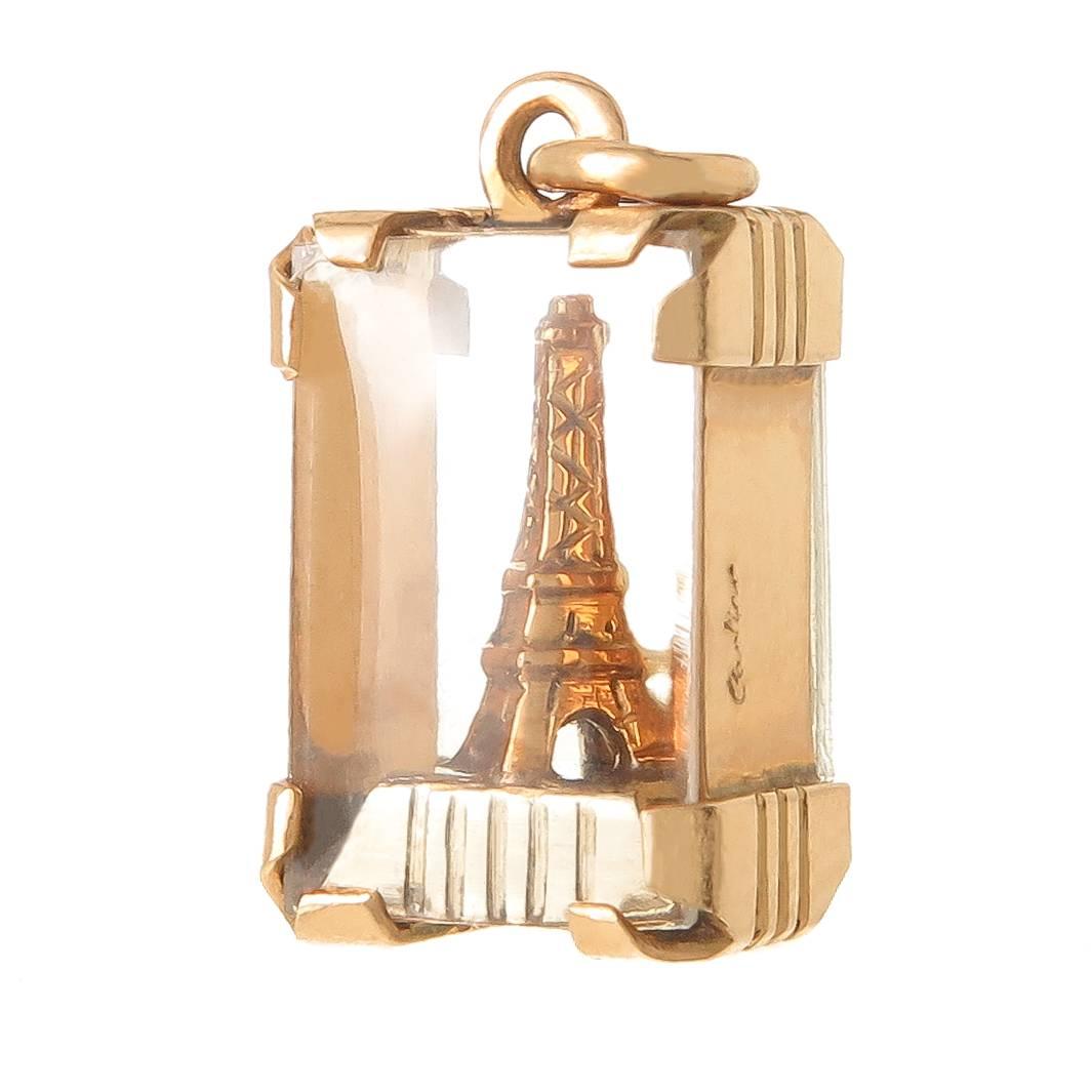 Circa 1950 Cartier 18K yellow Gold Eiffel Tower Charm encased in Gold and Glass, measuring 1/2 X 1/4 inch. Signed and Numbered, never worn and comes in the original gift box.