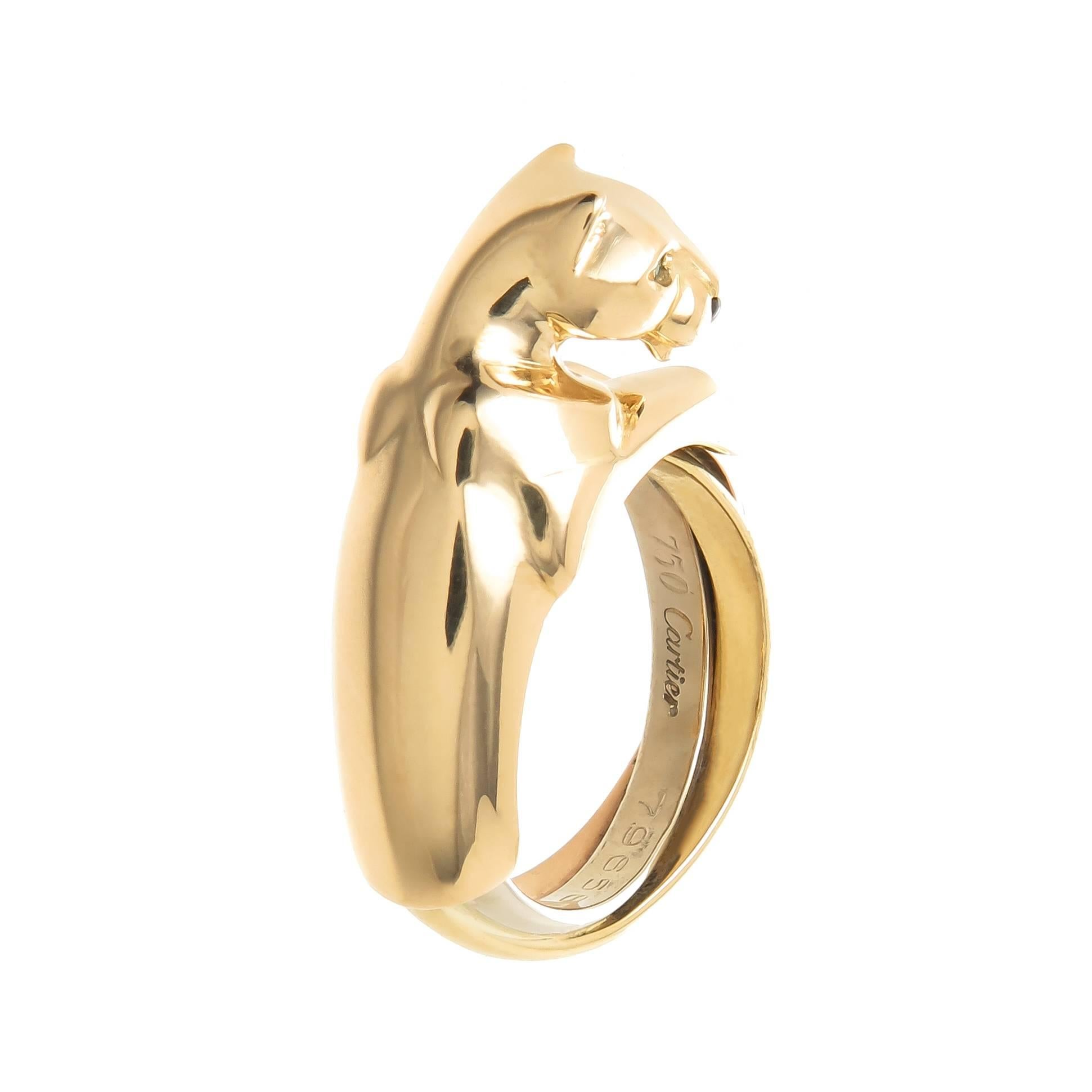 Circa 2000 Cartier Panther trinity ring. 18K Yellow Gold Panther atop Yellow, Rose and White Gold Trinity Bands. Emerald Eyes and a Black onyx Nose. Finger size 4. Comes in original Cartier presentation Box.