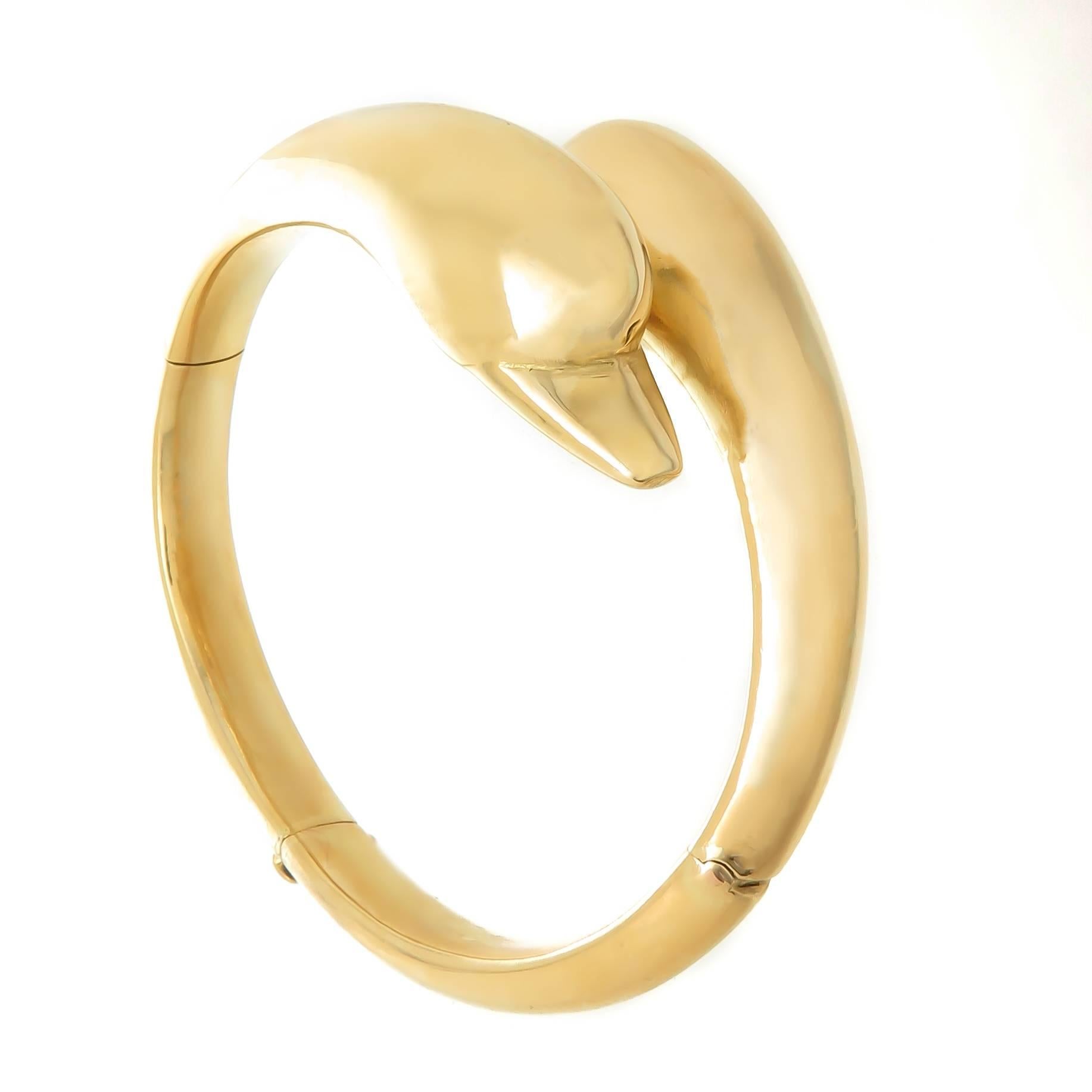 Circa 1980s LalaOunis 22K Yellow Gold Double Dolphin head Bangle Bracelet, the heads each measure approximately 1 1/4 inches in length, the inside measurement is 6 3/8 inches with a double hinge for easy on and off and a safety lock. Weighing 42.7