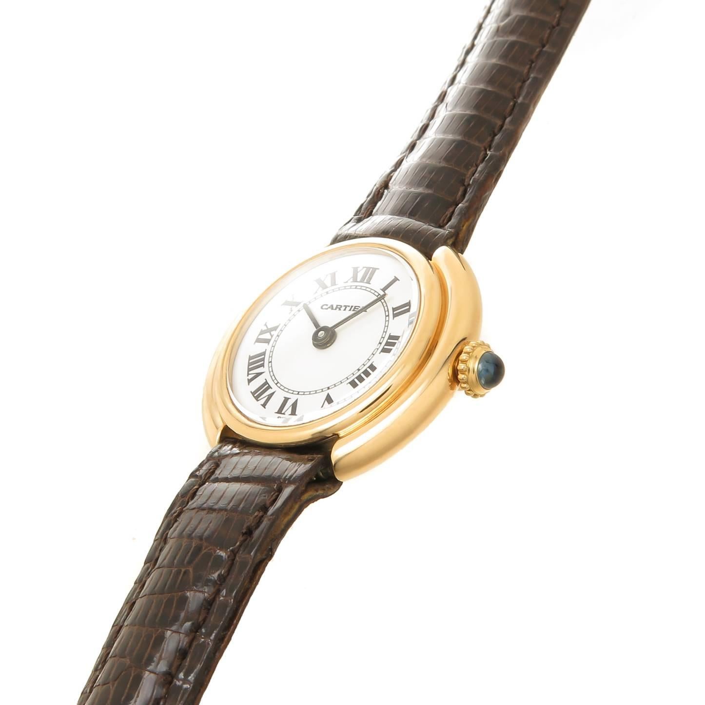 Circa 1970s Cartier Ceinture Ladies Wrist Watch, 26 X 23 MM 18K Yellow Gold Case, mechanical, Manual wind Movement, White Dial with Black Roman Numerals, Sapphire Crown. New DeBeers Paris, brown Lizard Strap with original Cartier gold plated Tang