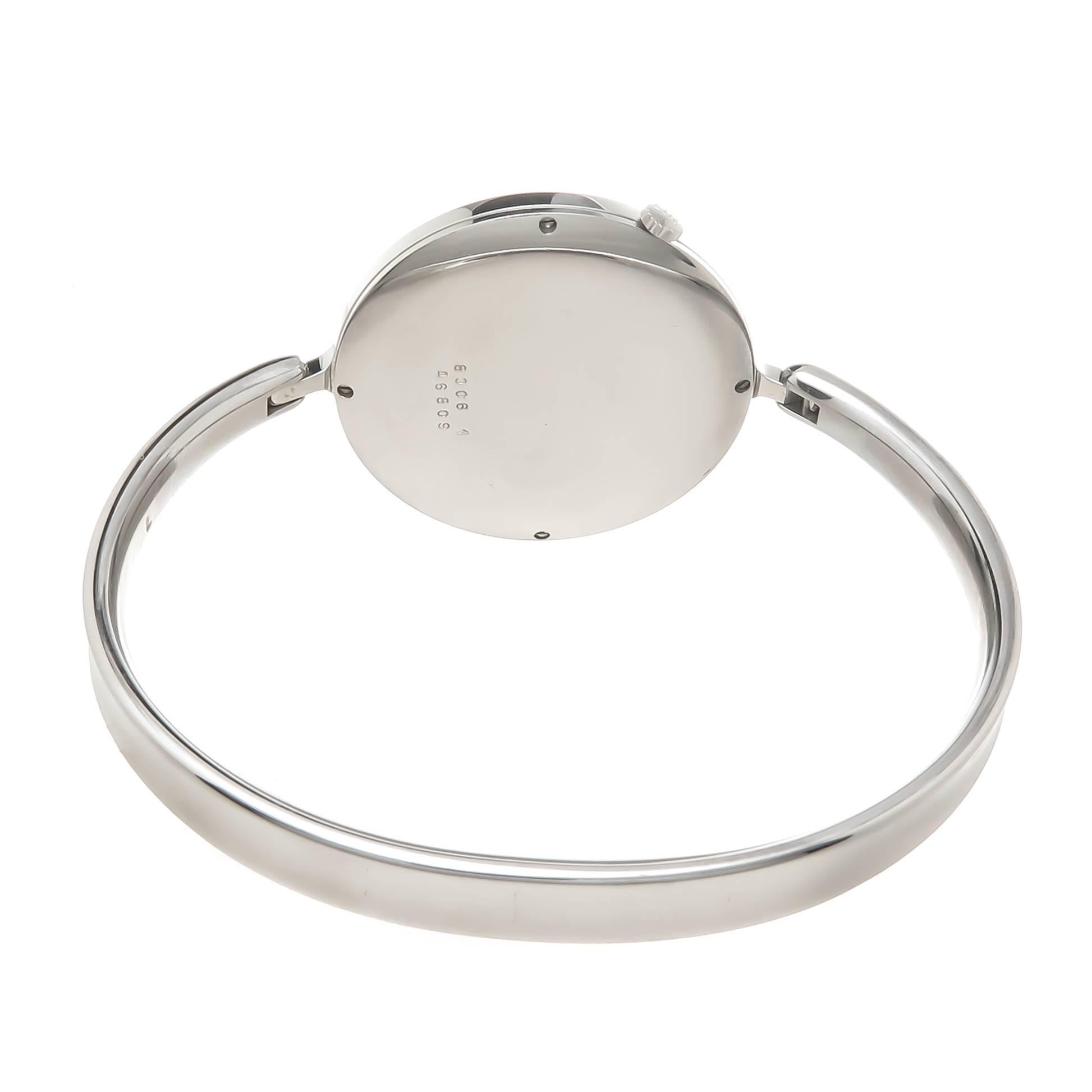 Circa 1990s Georg Jensen Vivianna Bangle Watch By Torun. 1 1/4 inch Diameter watch attached to a 3/16 inch wide bangle bracelet with a 6 1/2 inch inside measurement. Quartz Movement, silvered mirrored Dial. Comes with a Georg Jensen Travel pouch,