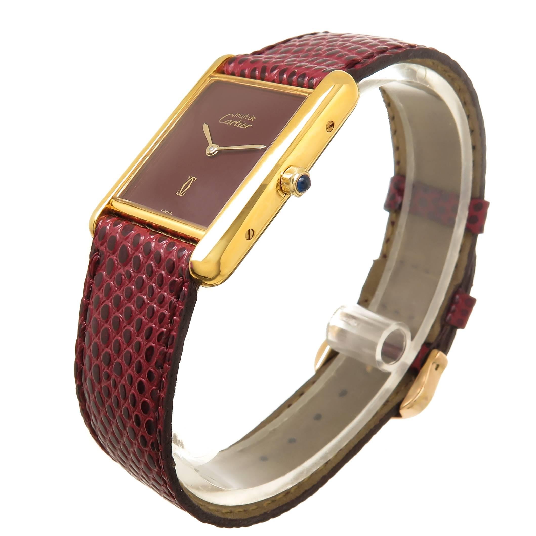 Circa 1990 Cartier Vermeil ( Gold Plate Sterling Silver ) Wrist watch, 30 X 24 M.M. Case, Quartz Movement, Burgundy Dial and a Sapphire Crown. New Burgundy Lizard strap with original Cartier Gold Plate Tang buckle. Watch length 8 1/2 inches.