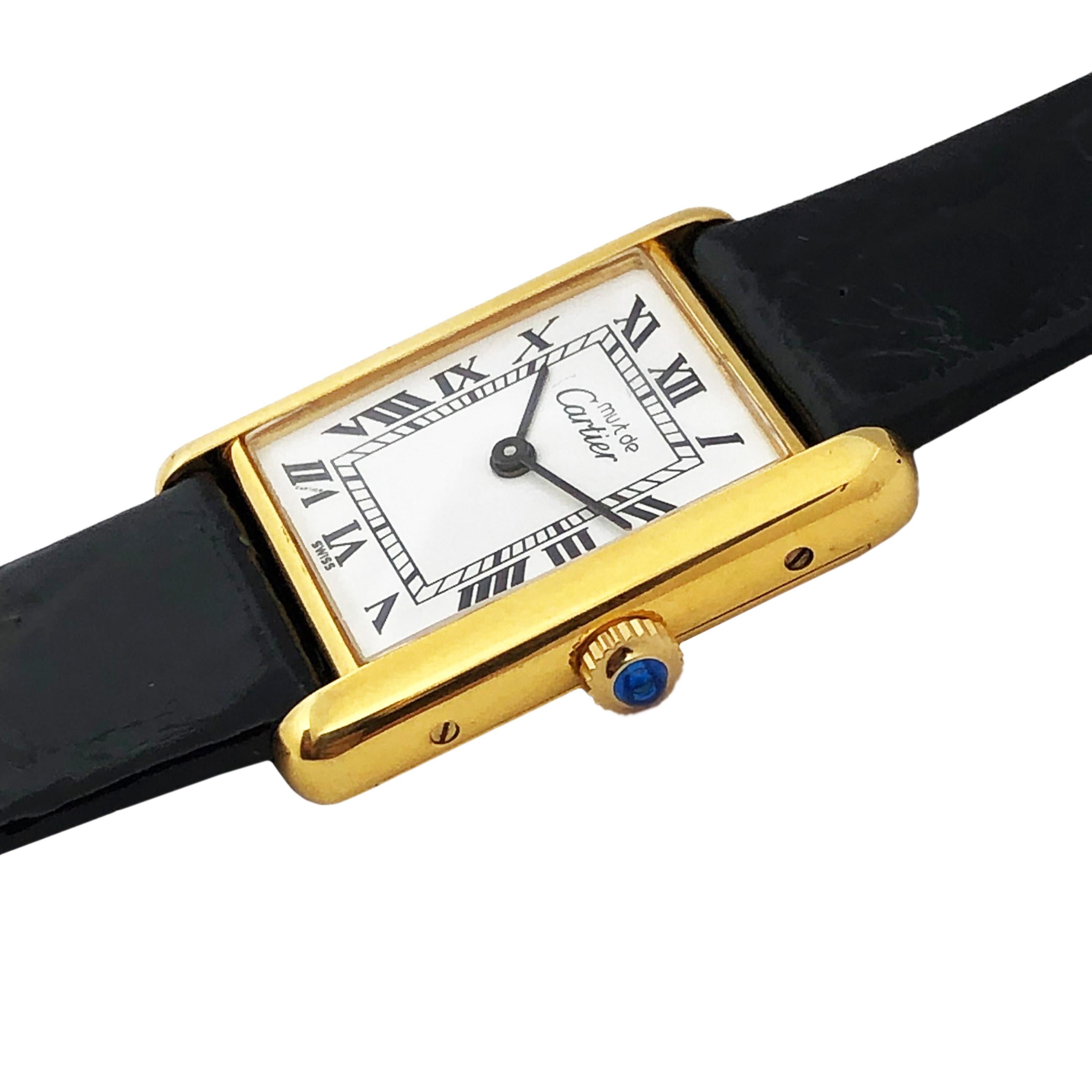 Circa 1990 Cartier Must De Cartier Standard Size Classic Tank Wrist Watch, 30 X 23 MM Vermeil ( Gold plate on Sterling Silver ) 2 Piece case. White dial with Black Roman Numerals, mechanical, manual wind 17 Jewel movement, sapphire crown. New Black