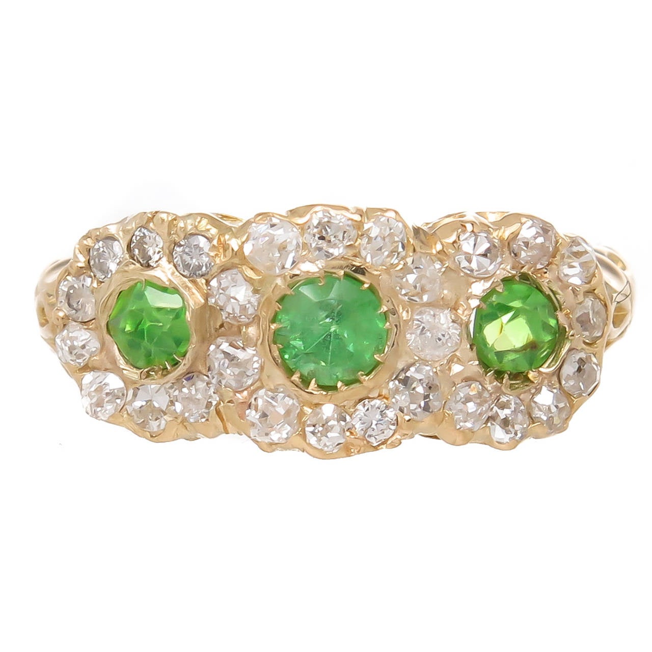 Circa 1910 14K Yellow Gold Ring set with 3 Round Demantoid Garnets two measuring 2.5 MM and the center measuring 3 MM, all are surrounded by Old Mine cut Diamonds totaling 1 Carat. measuring 5/8 inch in length across the top and 1/4 inch wide.Finger