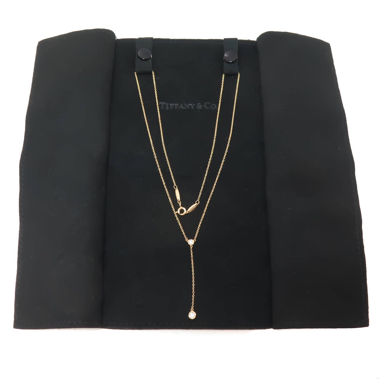 Circa 2014 Elsa Peretti for Tiffany & Company Diamonds by the Yard Drop Necklace. 18K Yellow Gold with two round Brilliant cut Diamonds totaling .19 Carat. Total Length 19 Inch. Original Presentation Fold.