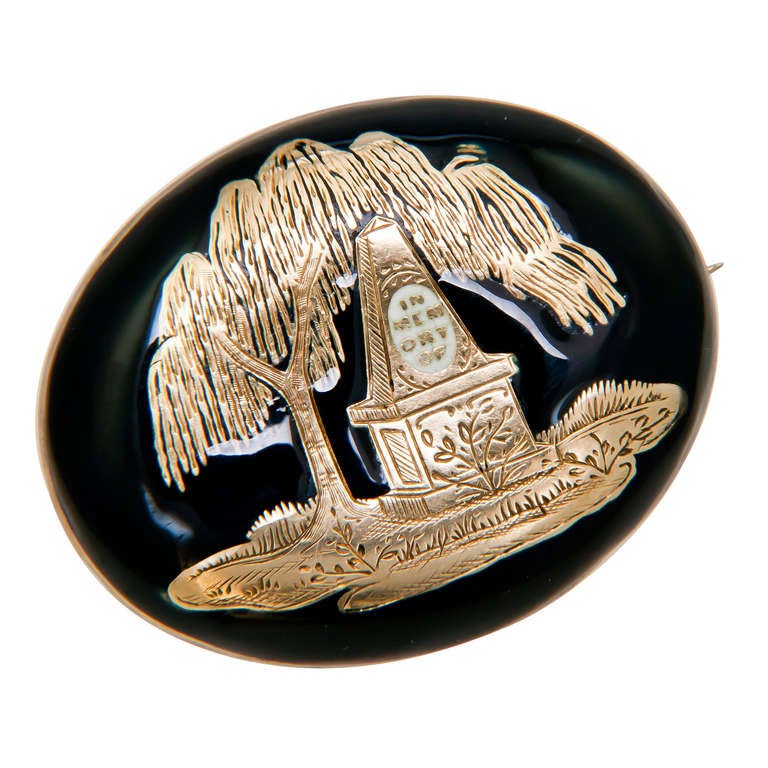 Circa: 1830s 12k yellow Gold Mourning Brooch, decorated in Black and white Enamel and hand engraved. The back of the piece has a Glass covered compartment with woven hair.