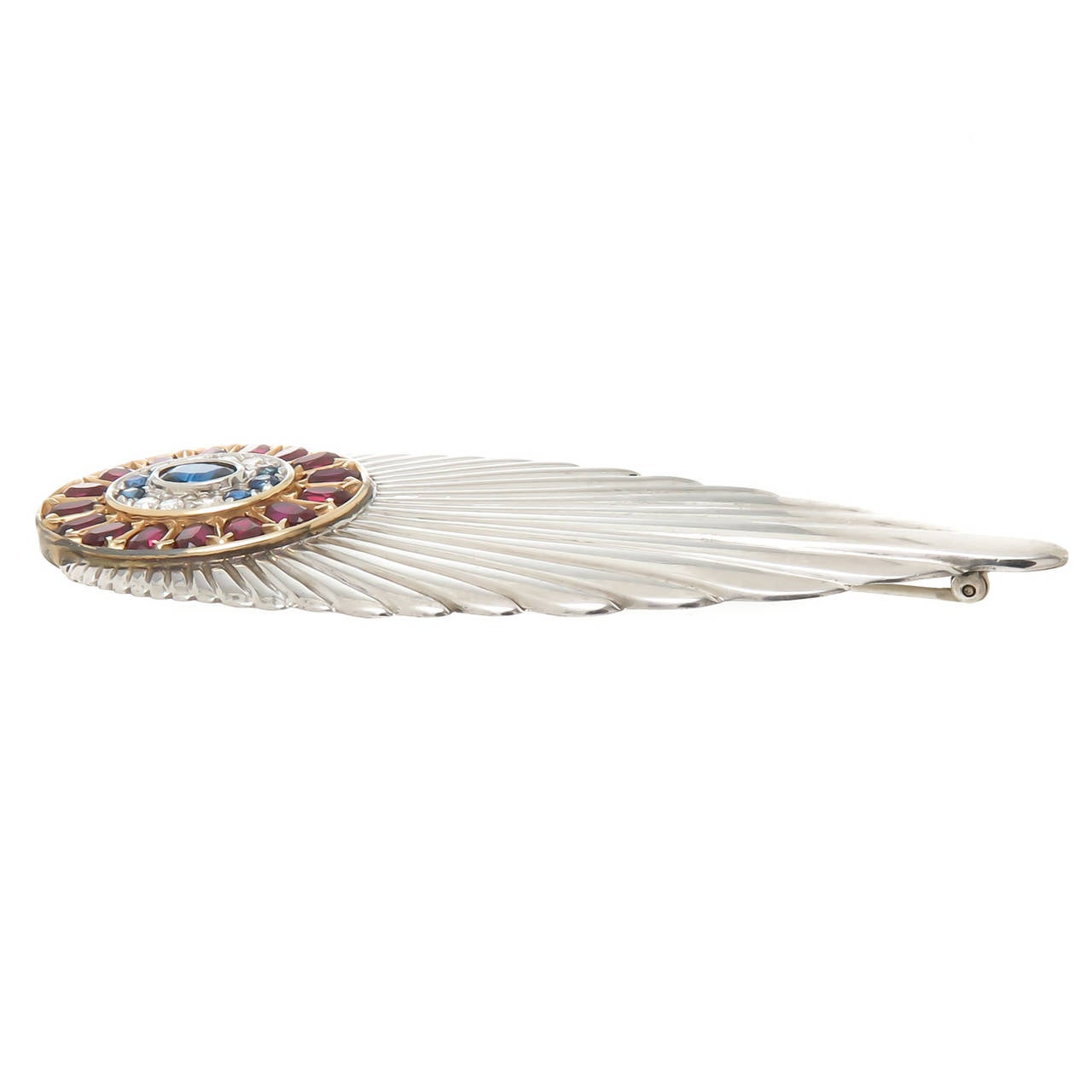 Circa 1980 Erte 14K yellow Gold and sterling silver Deco feather Brooch, set with Diamonds, Sapphires and Garnets. Measures 3 1/2 inch in Length and 1 3/8 Inch wide. With Original box from Circle Fine Art Galleries, the exclusive retailer of Erte