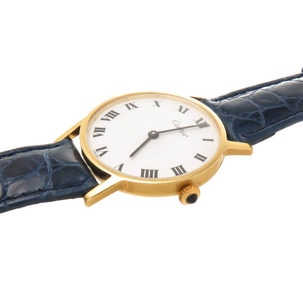 Circa 1980s Cartier Classic round 18K Yellow Gold Wrist Watch, 2 piece 31 MM case. Manual wind 17 Jewel, Cartier Inc Movement. Sapphire crown, White Dial, Black Roman Numerals. New Hadley Roma Dark Blue Leather Strap with Cartier Gold Plate Buckle. 
