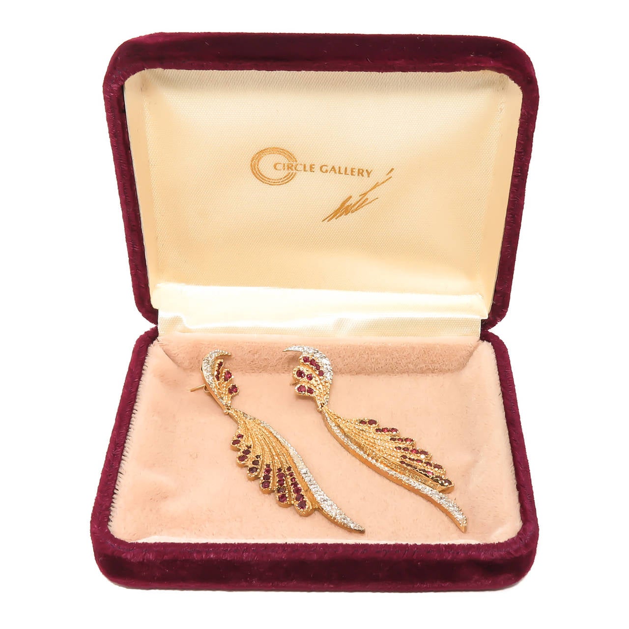 Circa 1980 Erte Fantasy collection Dangle earrings, 14K yellow gold set with Rubies and Diamonds. Measuring 3 inch in length and having post backs, signed and numbered and comes in the Original presentation case from Circle Fine Art Galleries.