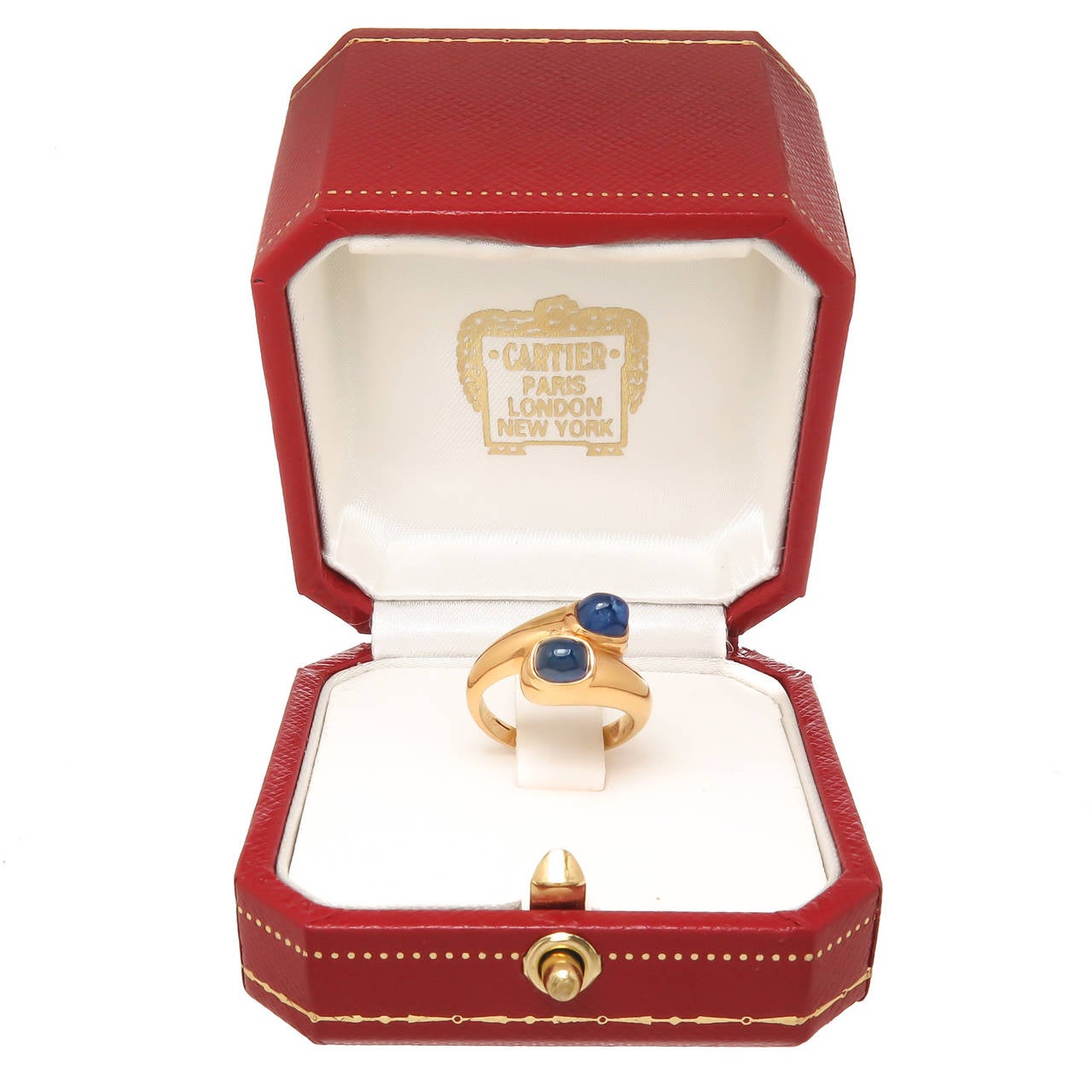 Cartier Paris 18K Yellow Gold bypass ring, set with two Domed Cabochon Sapphires of fine color possibly Burma measuring 4.5 x 3.5 x 3.5. Finger size = 4 1/2. Signed Cartier Paris and having two sets of numbers. Comes with a later Cartier