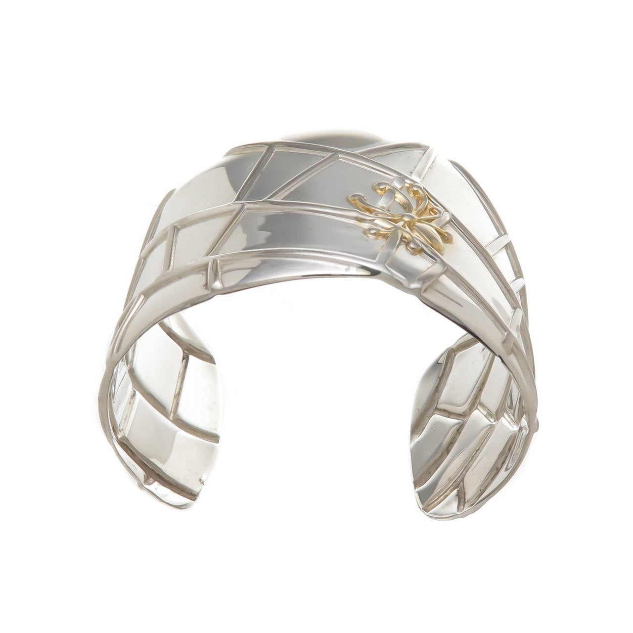 Circa 2003 Tiffany & Company Sterling Silver and 18K yellow Gold Spider Web Cuff Bracelet. Measuring 1 5/8 inch wide, can be adjusted to fit most any wrist.