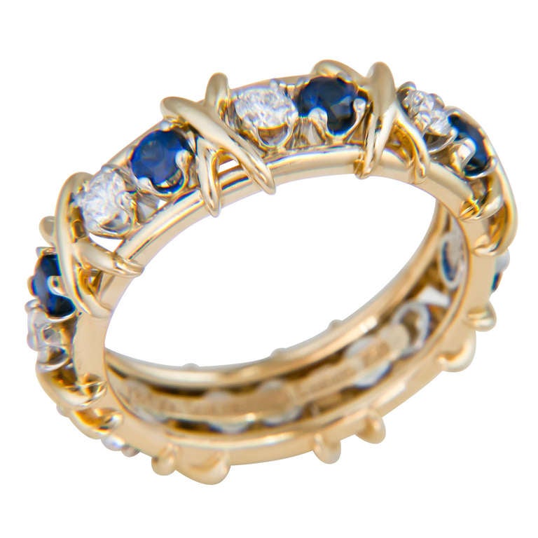 Jean Schlumberger for Tiffany & Co. 18K Yellow Gold, Diamond and Sapphire X Ring. Set with 8 Round Brilliant cut Diamonds and Sapphires. Finger Size 8.