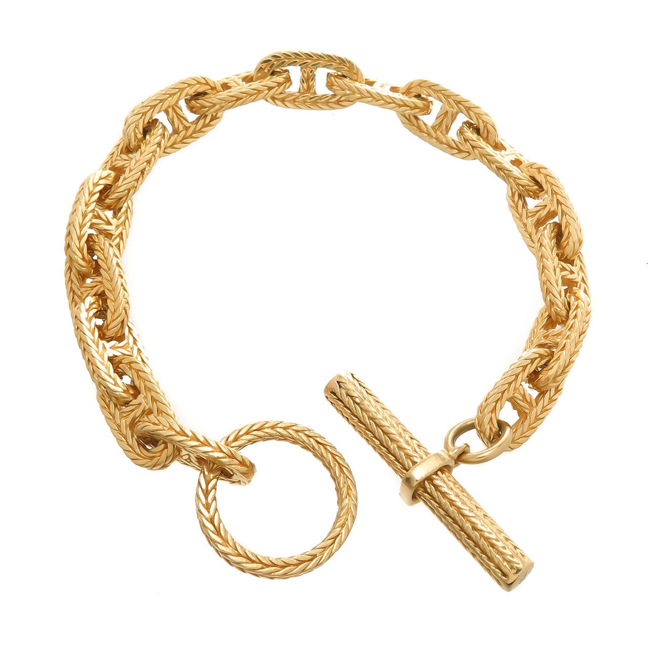 Hermes 18K yellow Gold Chaine D'Ancre Tresse Toggle Bracelet, Solid Links with a Toggle closure. Measuring 8 1/4 inch in Length and just under 3/8 inch wide.