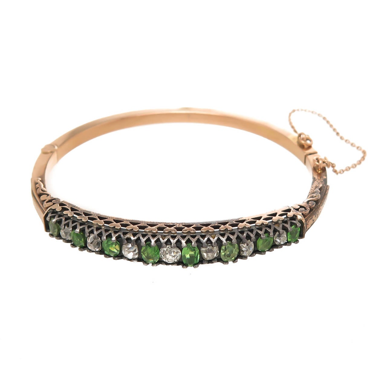 Circa 1900 Silver top and Gold bangle Bracelet possibly of Russian Origin and set with oval and oval Cushion cut Green Demantoid Garnets totaling approximately 2 Carats that are of Fine Bright Green Color typical of Russian Mined stones. Further set