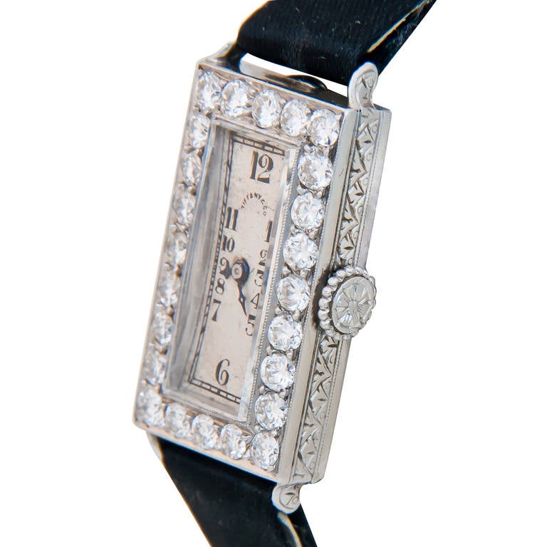 Circa 1920s Platinum and Diamond Lady's Watch by Audemars Piguet and Retailed by Tiffany & Co. 28 x 13 mm Contract Case with Hand engraved work on all sides including fancy engraved Platinum Crown. 24 European cut Diamonds totaling 1 Carat.
