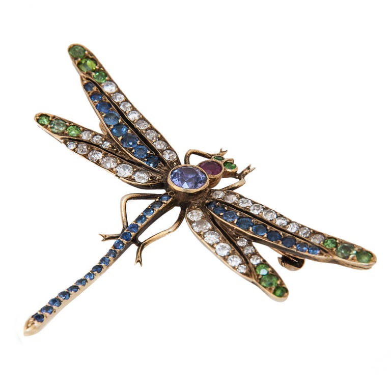 Circa 1910 yellow Gold Dragon Fly Brooch, very nicely detailed and centrally set with a Natural color change Purple sapphire further set with Demantoid Garnets. Diamonds, Ruby and Small sapphires. measures 2 1/4 inch from wing tip to wing tip.