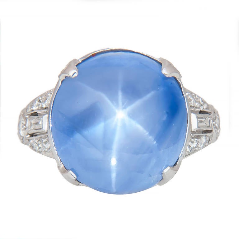 Circa 1930s Platinum Diamond and Star Sapphire Ring, 6 Leg Star Sapphire weighing approximately 16 Carats, Violet Blue Hue with noticeable Color Zoning.  The ring is further accented with baguette and round Diamonds all set in a pristine exquisite