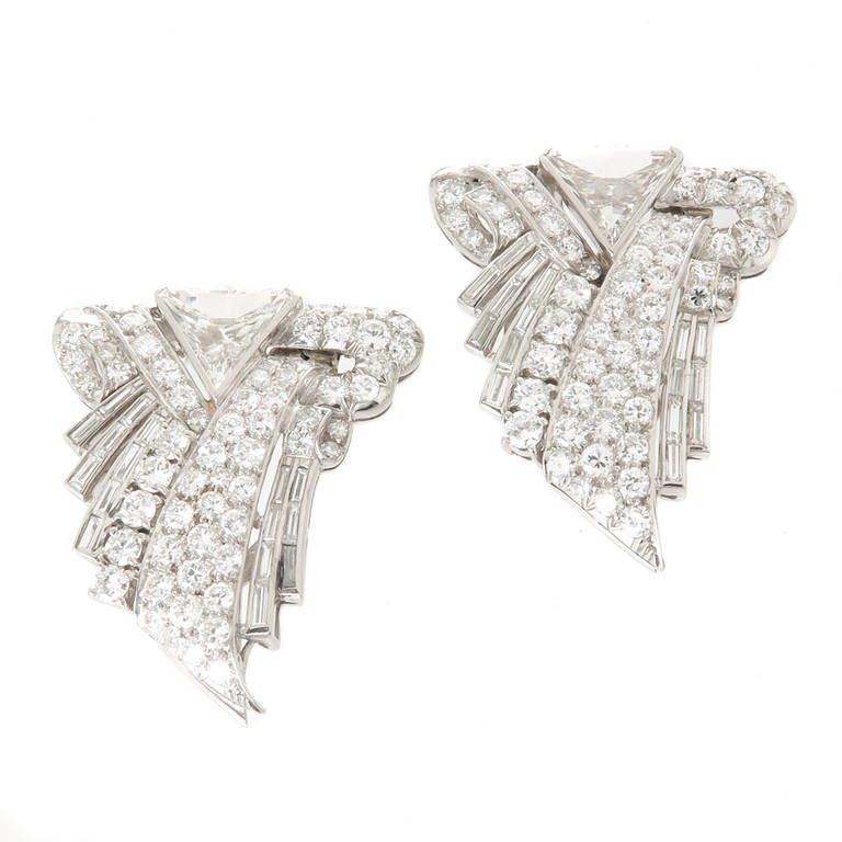 Circa 1930s Art Deco Platinum and Diamond Dress Clips that fasten together so as to be also worn as a single Brooch. Set with round and Baguette Diamonds totaling 3.25 carats and centrally set with stepped cut Triangle shaped Diamonds totaling 1.50