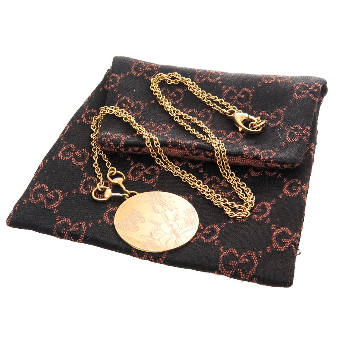 Circa 2005 Gucci 18K Yellow Gold 1 inch, 2 sided Floral Disk Pendant on a 20 inch link chain with Horse Bit connections. Signed, numbered and with Gucci Gift Pouch.