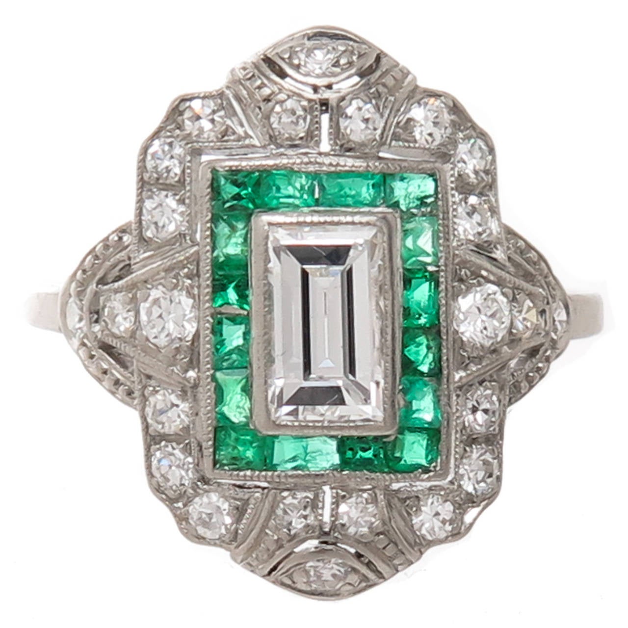Circa early 1930s Platinum, Diamond and Emerald Engagement Ring, centrally set with a stepped cut, Emerald Cut Diamond that is 3/4 carat and is H in Color and VS in Clarity, surrounded by Emerald cut Emeralds of Fine Color. The ring is further set