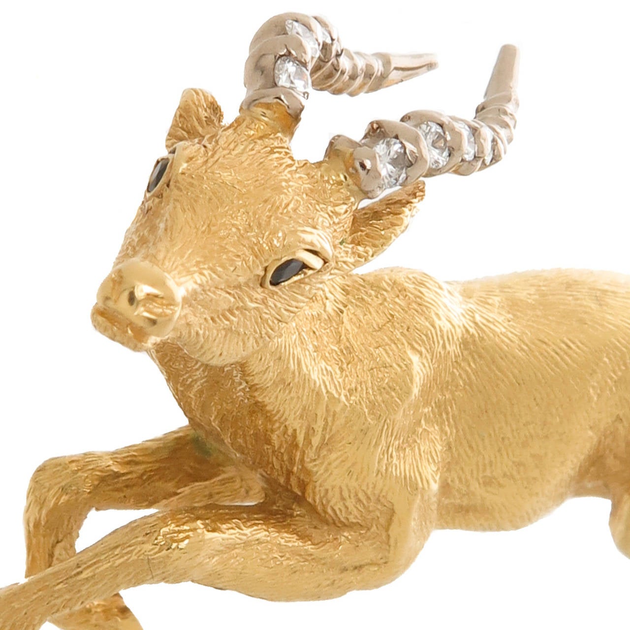 Circa 1990s 18K Yellow Gold and Diamond set Gazelle Brooch, further accented with Sapphire eyes, textured finish and very well detailed. Measuring 2 inch in length. Original Tiffany Presentation Box.