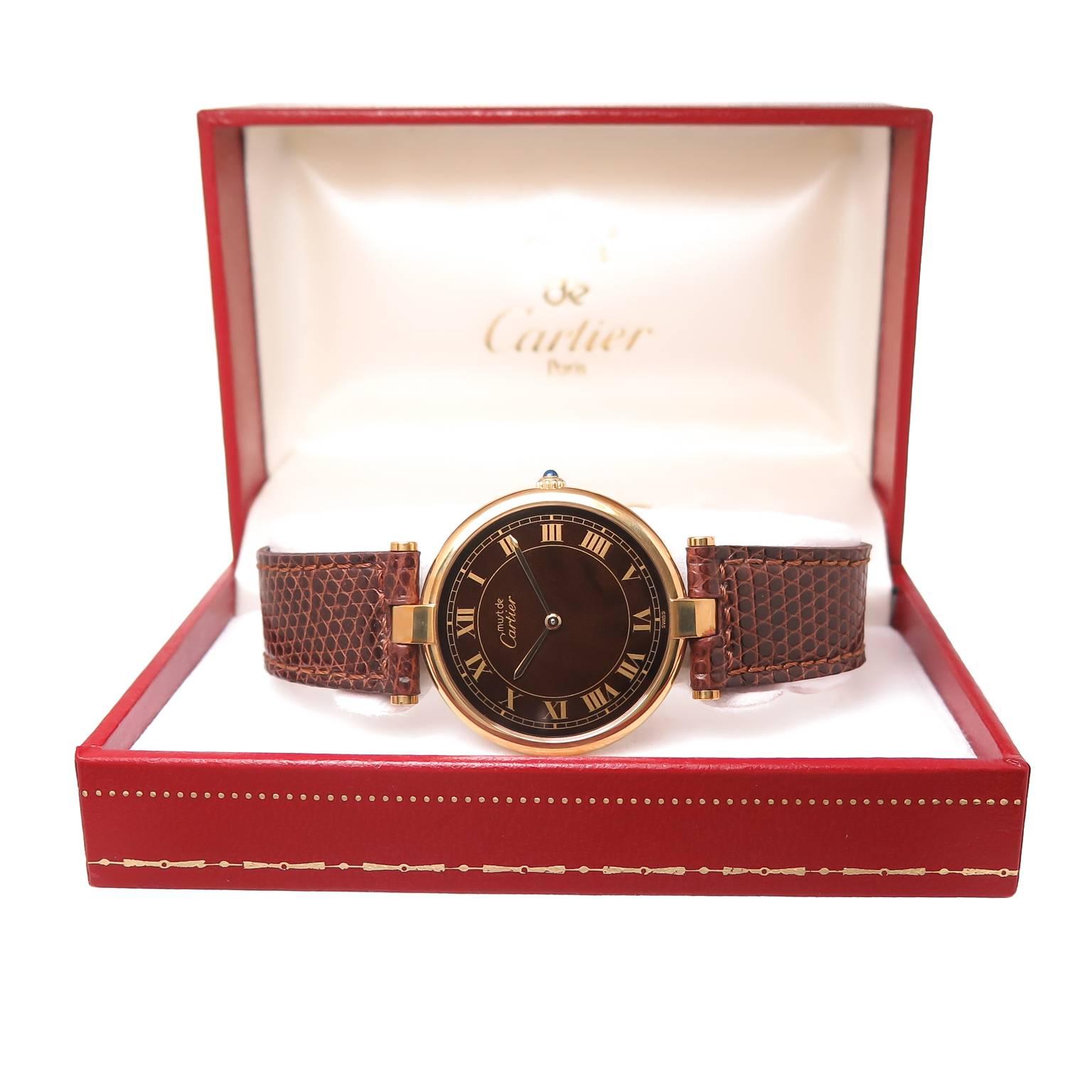 Circa 1990 Never Worn Cartier Vermeil ( Gold Plated Sterling Silver ) Vendome Collection Wrist Watch. 30 MM Water Resistant case, Quartz Movement, Brown Dial with Gold Roman Numerals, sapphire set Crown. Brown Cartier Lizard strap and a Vermeil
