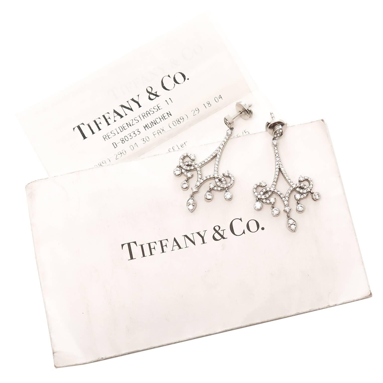 Circa 2012 Tiffany & Co. Platinum Scroll Earrings, set with round Brilliant cut Diamonds that are fine white F-G color and VVS Clarity and total 1.45 carat. Measuring 1 3/4 inch in length, 7/8 inch wide and having dangling bottom sections. Post