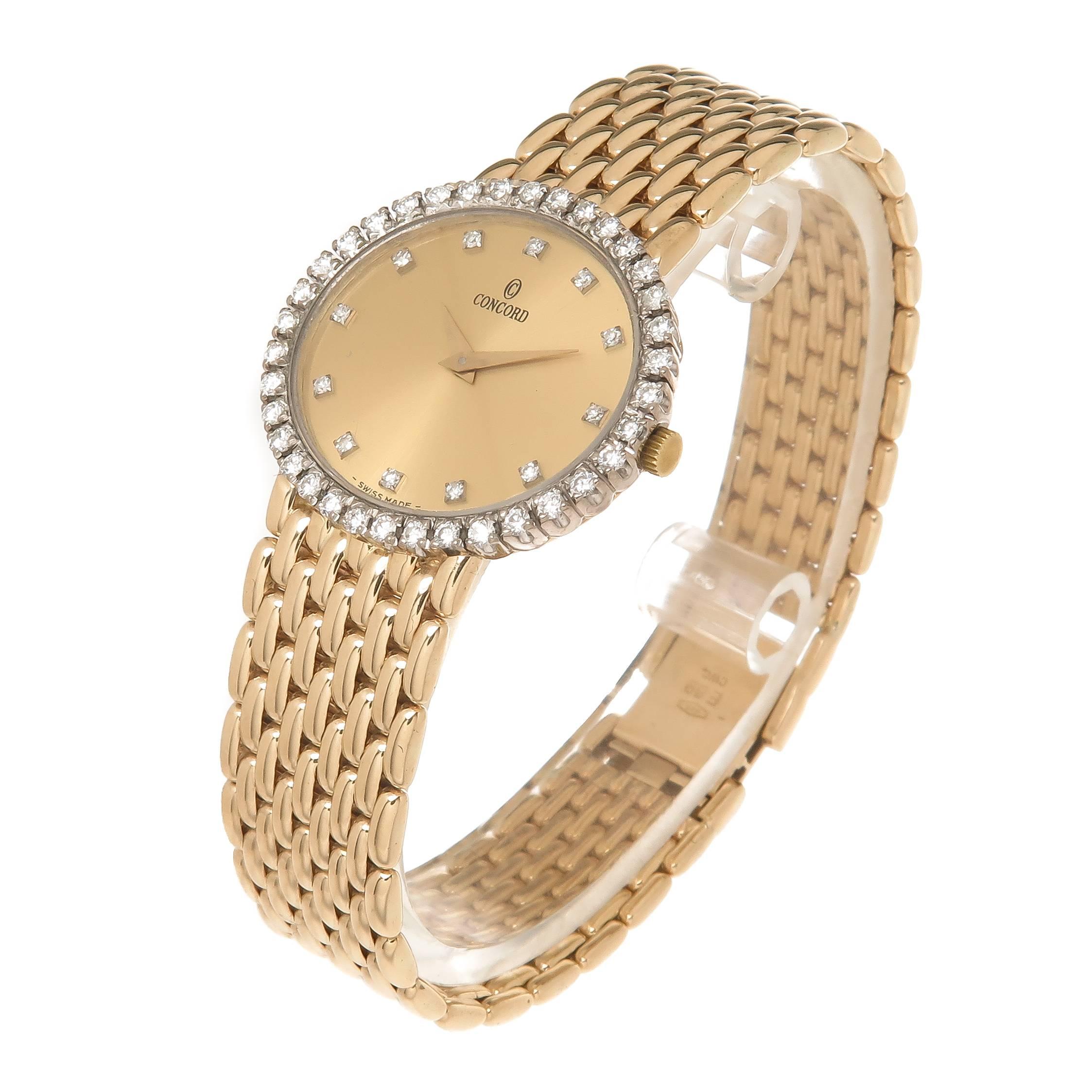 Circa 1990 Concord 14K yellow Gold Ladies watch, Water Resistant Case measuring 1 X 7/8 inch and attached to a Yellow Gold Link Bracelet measuring just over 1/2 inch wide. Total Length 6 7/8 inch. Quartz Movement, Gold Dial with Diamond set Markers.
