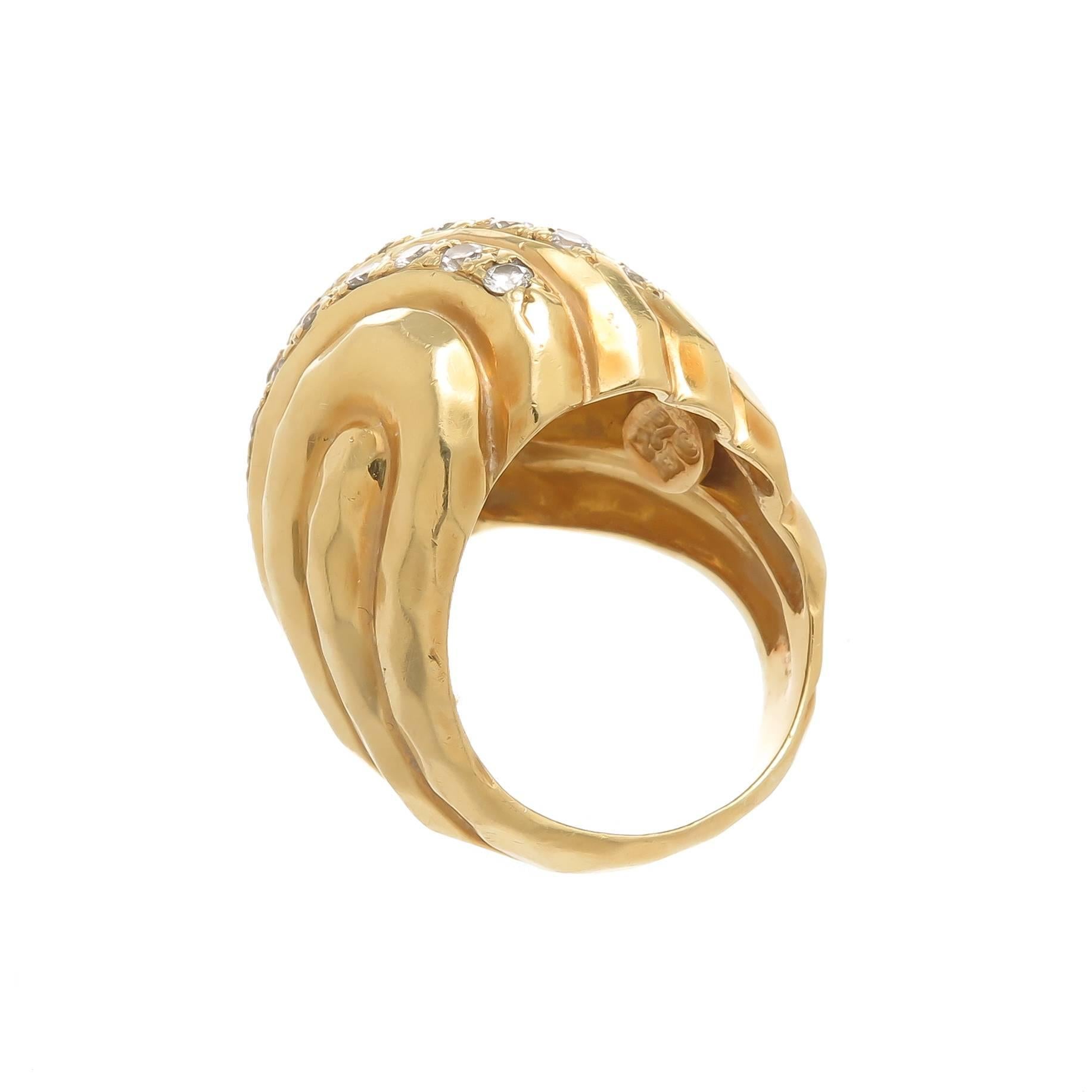 Circa 1990s Henry Dunay 18K Yellow Gold Domed Ring with Classic Dunay Hammered Finish. The ring measures 1 inch in length across the top and 7/8 inch wide. Set with 3 rows of Round Brilliant cut Diamonds totaling 1 Carat and Grade as G in Color and