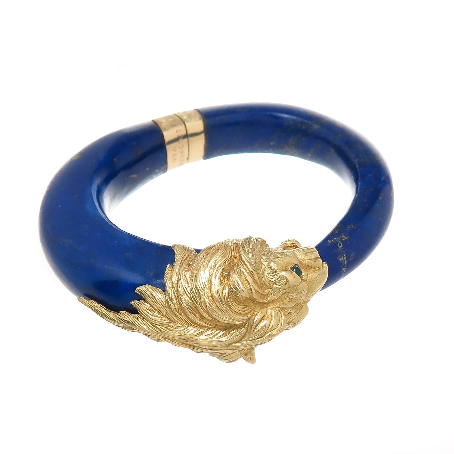 Circa 1960s Van Cleef and Arpels Lapis Lazuli and 18K Yellow Gold Lion Bracelet. Very detailed and having Emerald Set Eyes. The Lapis is a Gem Blue color with Gold flecks and tapers from 3/8 to 5/8 inch thick.Fitted with a very intricate opening