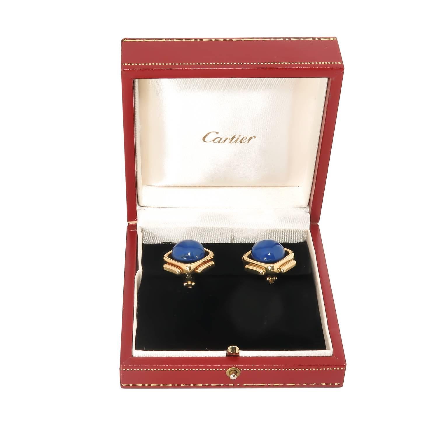 Circa 1970 Cartier 18K Yellow Gold and Lapis Lazuli Clip Earrings in a very pleasing Mid Century design the earrings measure 1 X 1 Inch and are centrally set with a Gem color Lapis domed Button. very well made clip backs, signed, numbered and in the