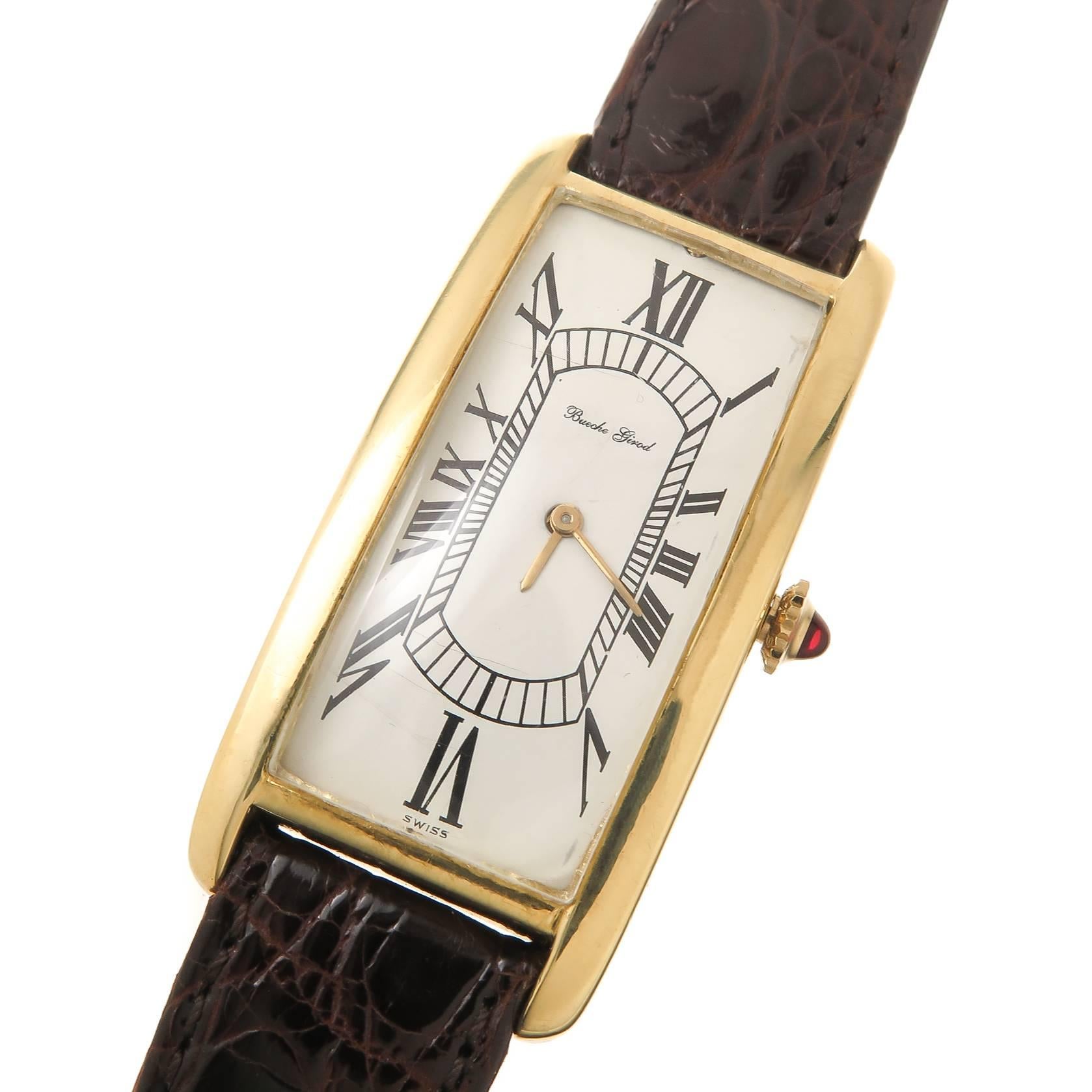 Circa 1970 bueche Girod 18K yellow Gold Wrist Watch, measuring 2 inch in Length and 7/8 inch wide with a significant wrist fitting curve. 17 jewel mechanical, manual wind Movement, White dial with Black roman numerals and   a Ruby set Crown. New