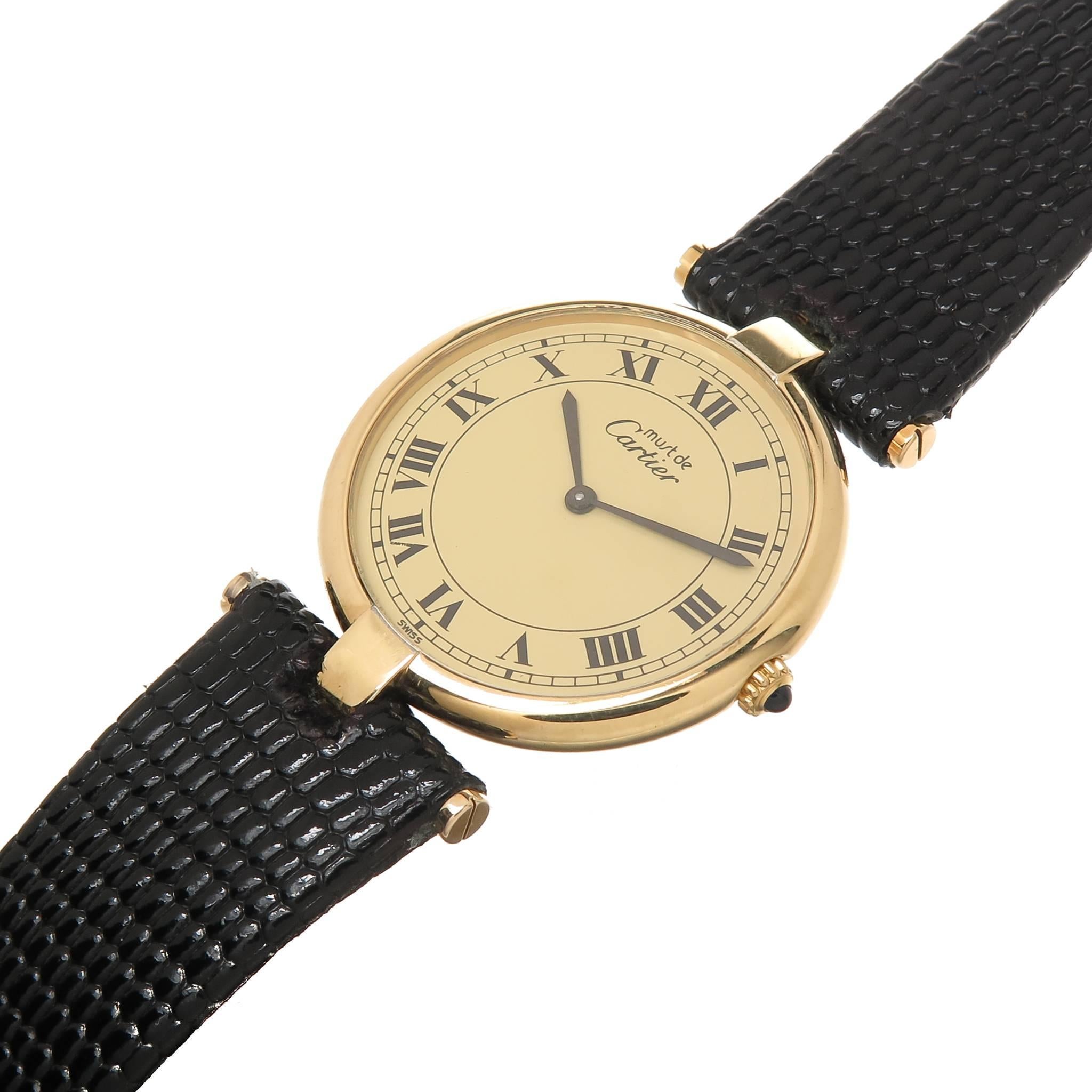 Circa 2000 Cartier Vermeil, Gold Plate on Sterling Silver, Must De Cartier Watch. 30 MM Water Resistant case, Quartz Movement, Gold Dial with Black Roman Numerals, Sapphire Crown. New Black Leather Strap. Comes in a Suede Cartier pouch and has its