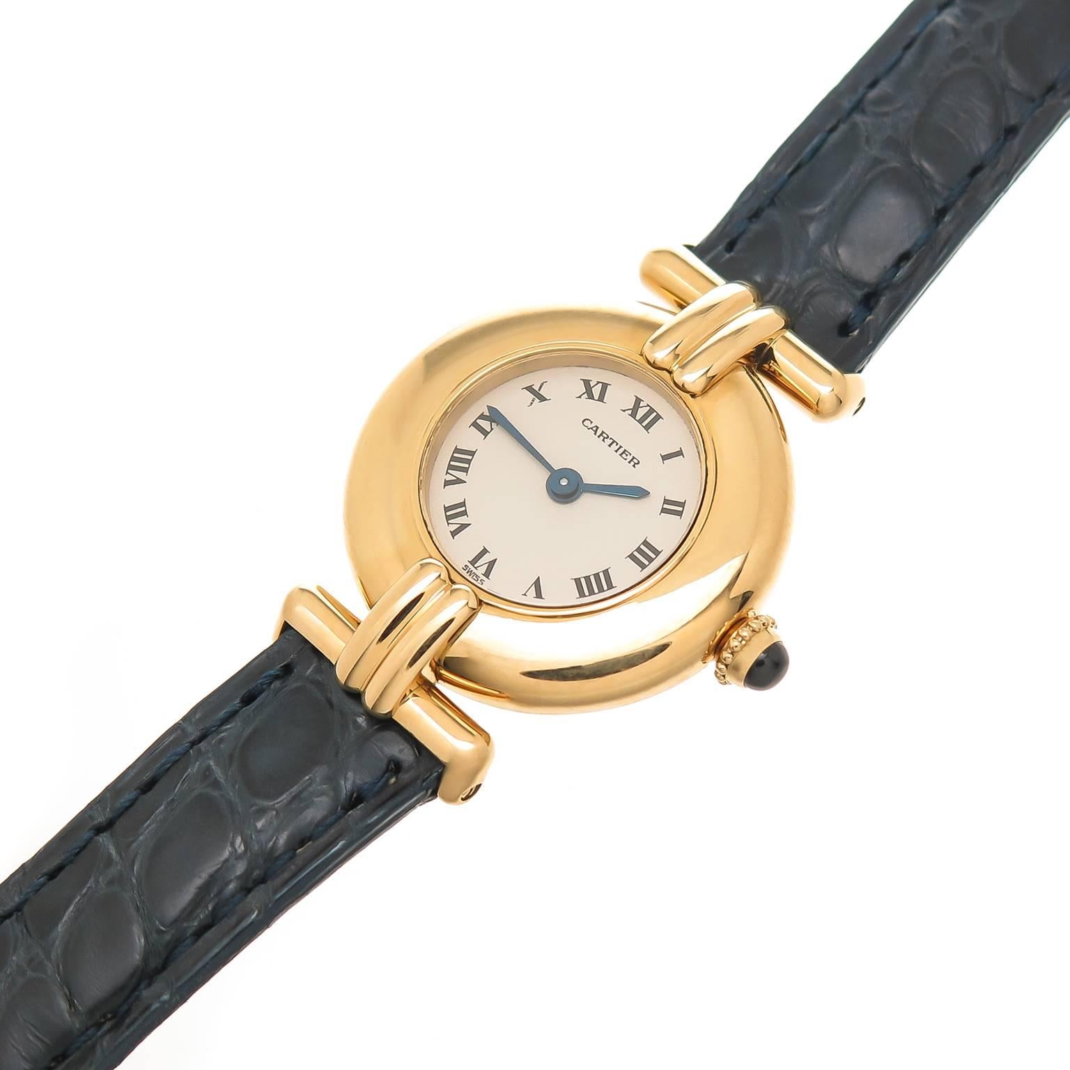 Circa 1990s Cartier Colisee collection Ladies Wrist watch, 24 MM water resistant case. Quartz Movement, White Dial with Black Roman numerals, sapphire crown. New, Cartier Navy Blue Textured Strap with Cartier 18K Yellow Gold Tang buckle. Comes in